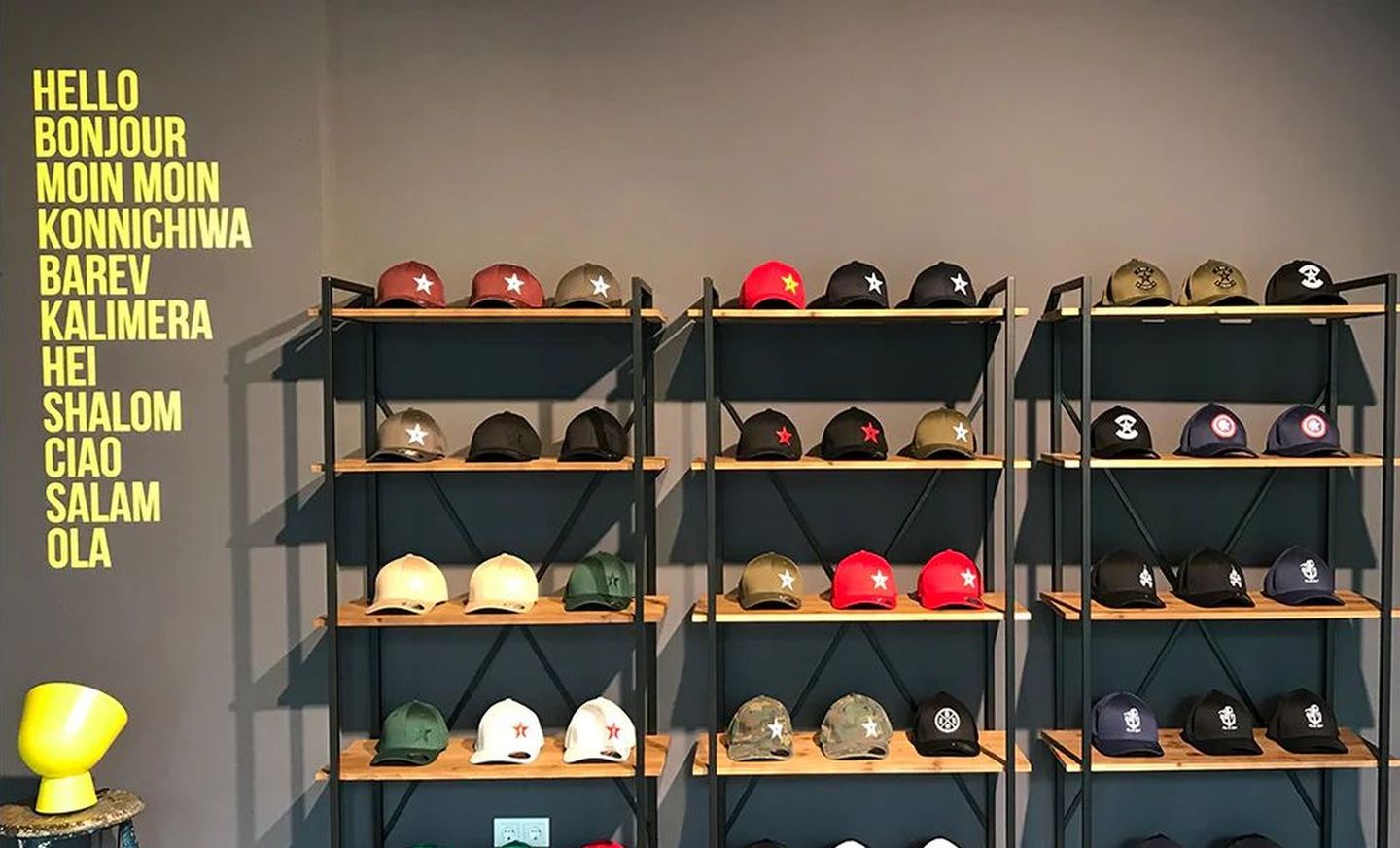 Modische Caps mit Druck liegen in Regalen aus. © null:zwo:elf