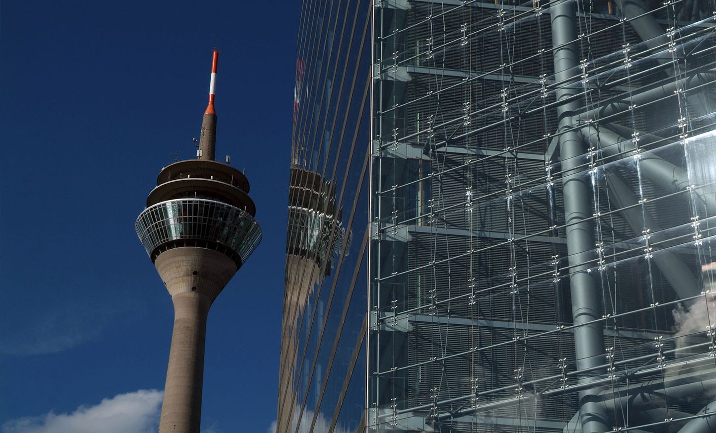 Der Rheinturm mit Spiegelung im Stadttor in Düsseldorf, der Landeshauptstadt von Nordrhein-Westfalen.