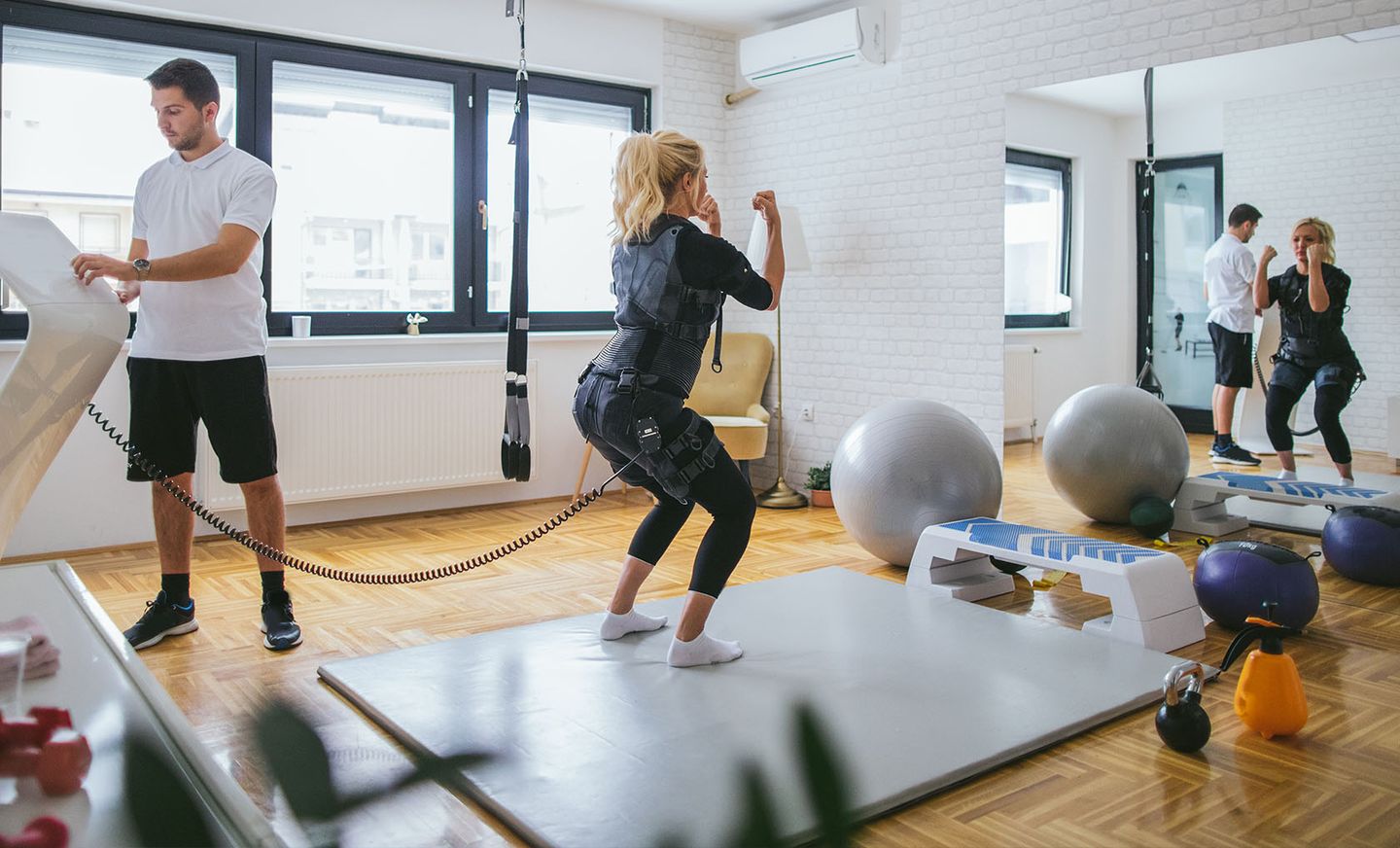 EMS-Training: Eine blonde Frau in schwarzer Funktionskleidung.
