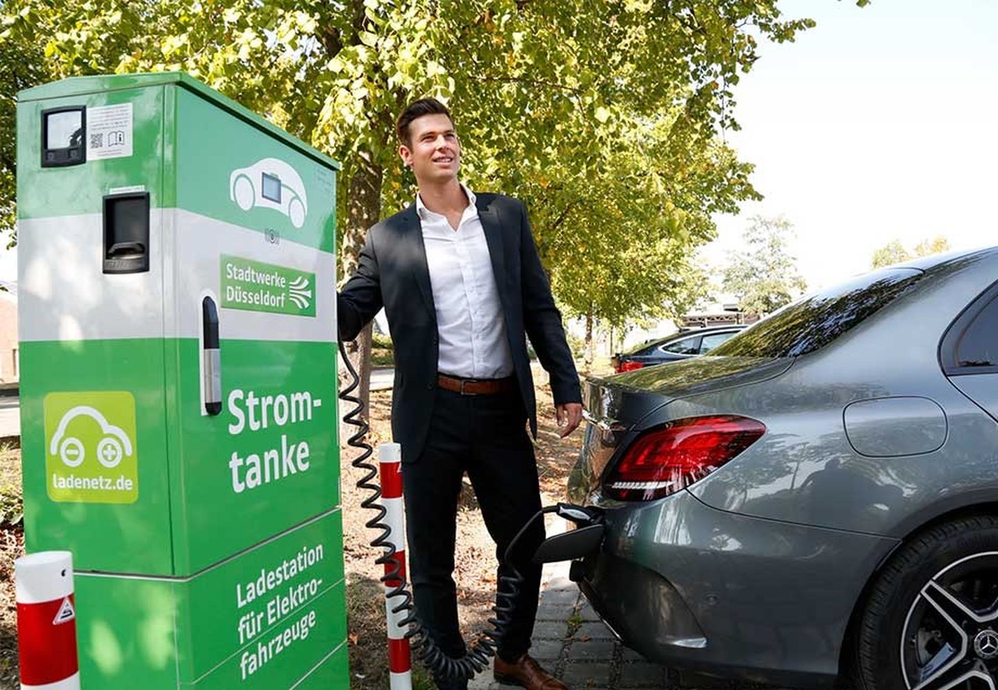 Mobilität der Zukunft: Ein Mann lädt sein E-Auto an einer Ladestation auf.
