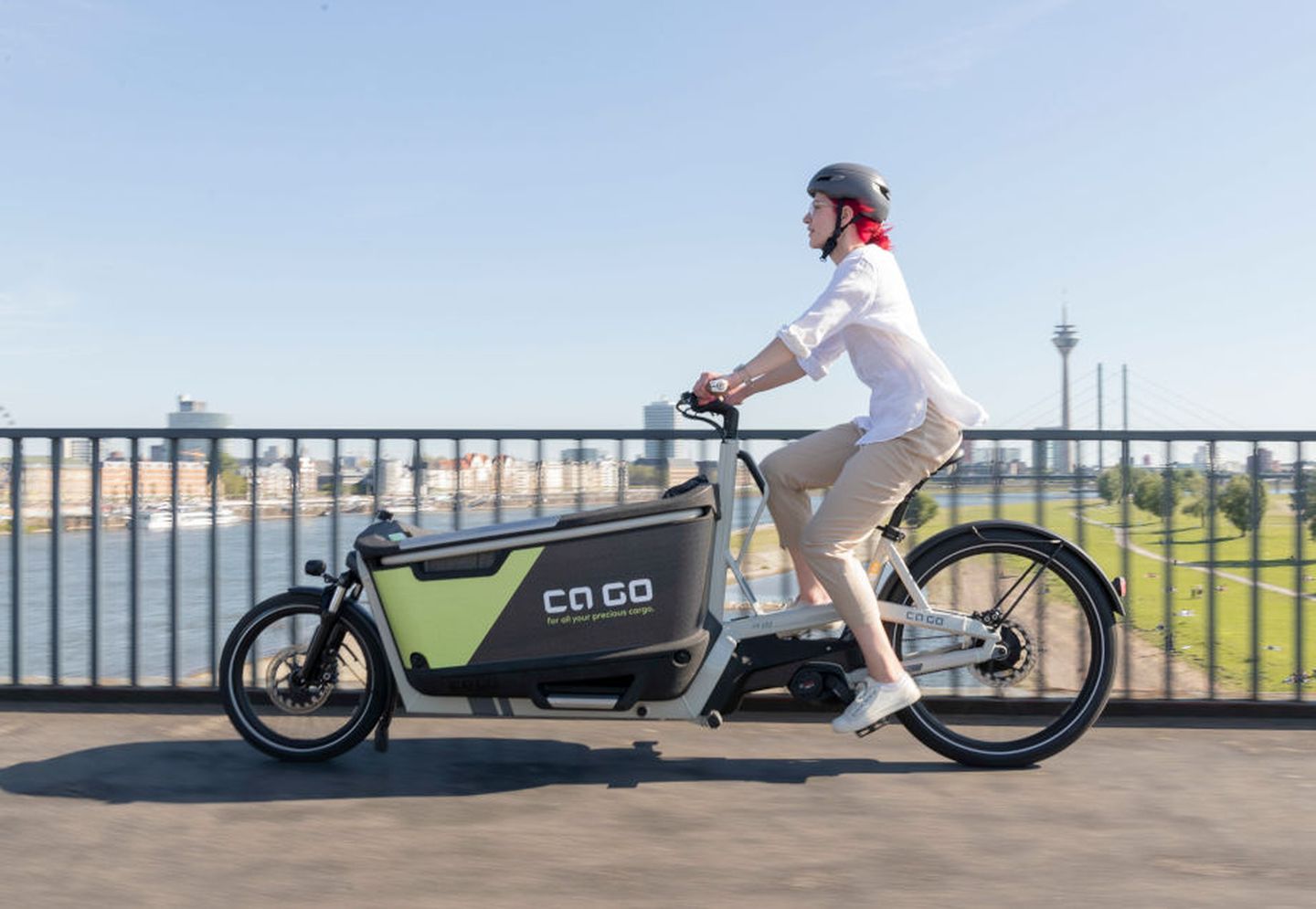 Eine Frau fährt mit dem E-Lastenrad durch Düsseldorf