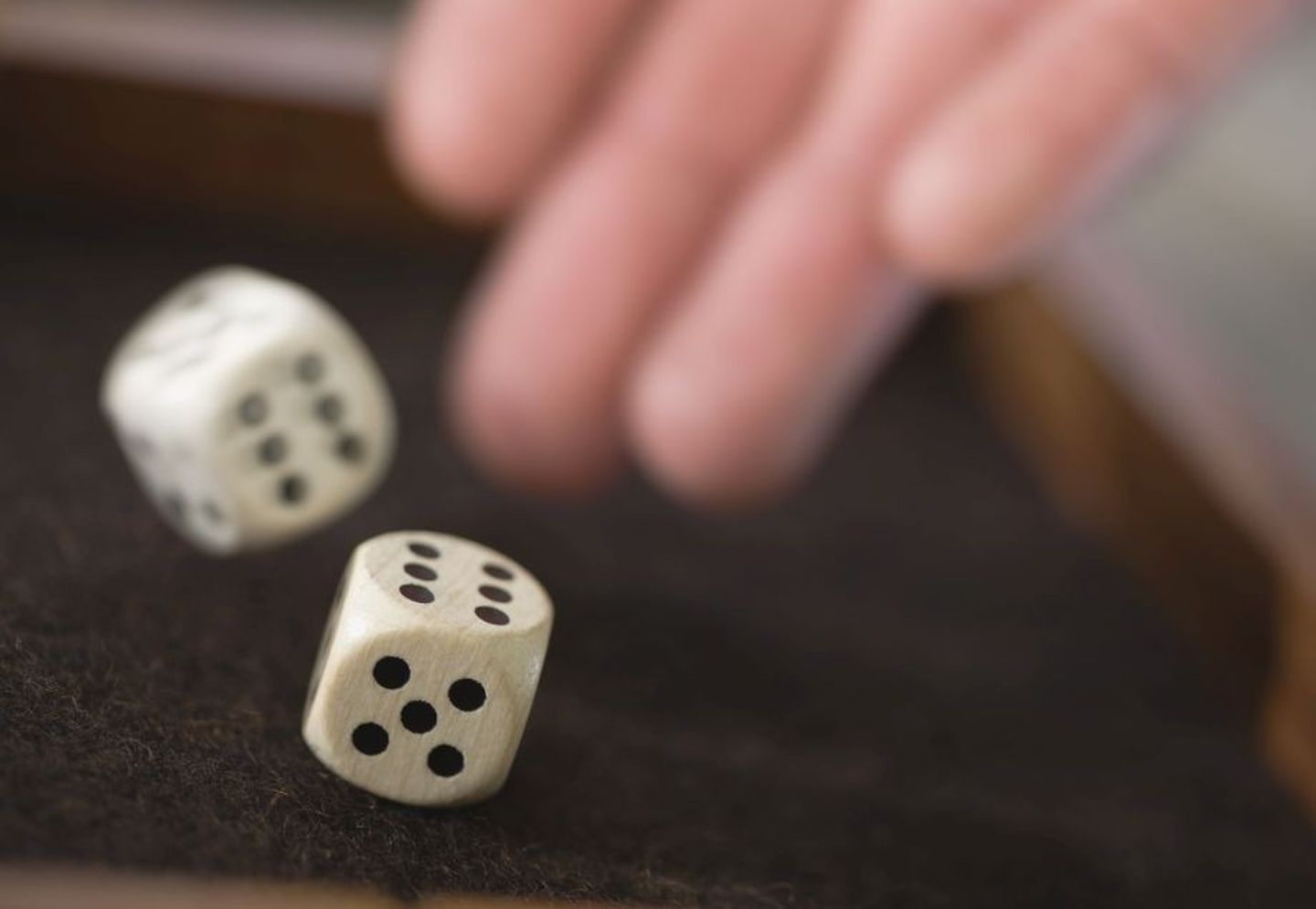 Schrottwichteln: Eine Hand wirft zwei Würfel