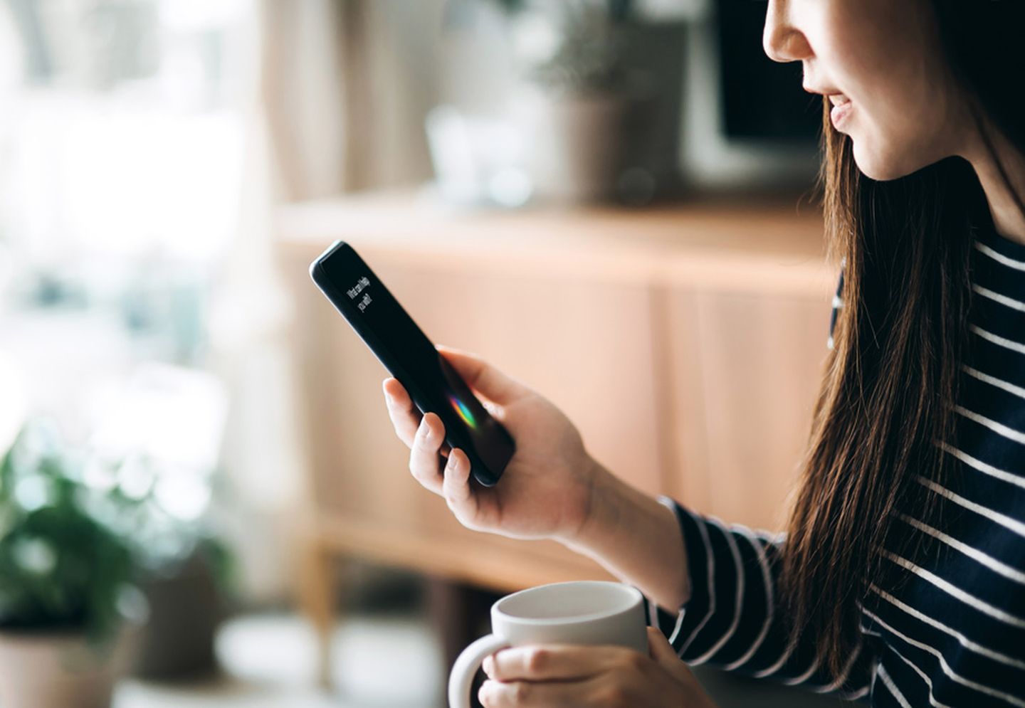 Eine Frau spricht mit ihrem Sprachassistenten auf ihrem Smartphone.