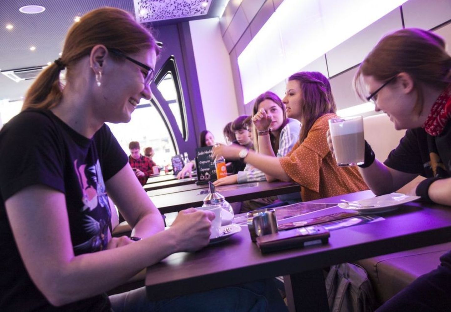 Besucherinnen des Holocafés sitzen lachend mit Kaffee am Tisch.