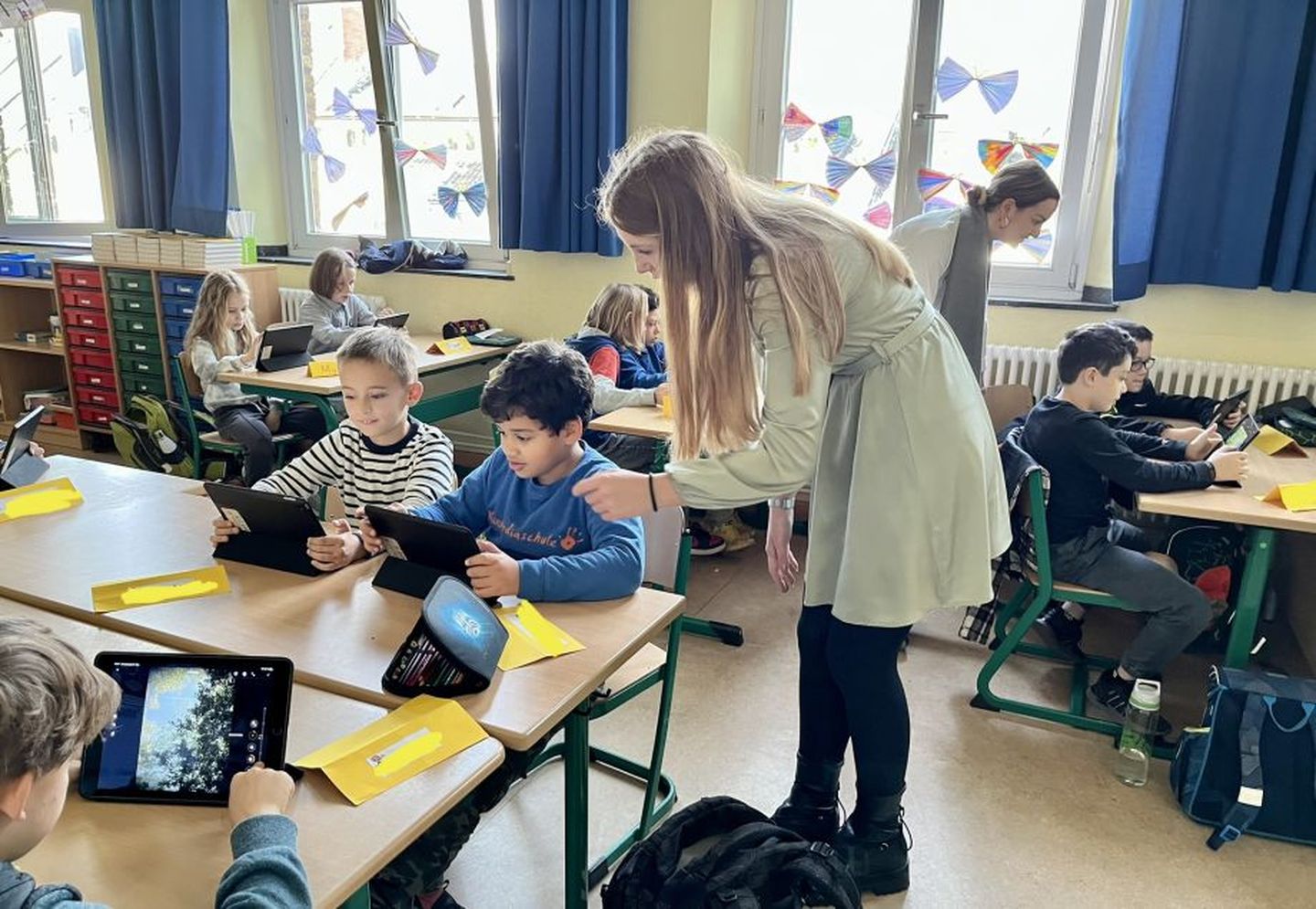 Die Auszubildenden Lilith Ney (vorne) und Laura Beck Lozano vermitteln den Schüler:innen den Umgang mit modernen Medien. © Stadtwerke Düsseldorf