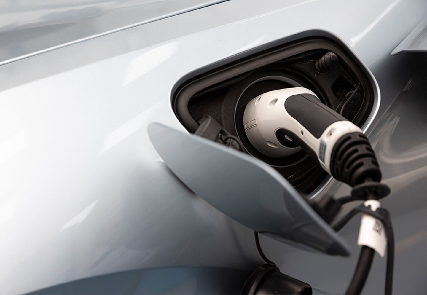Eine Ladepistole steckt im E-Tankstutzen eines Autos.