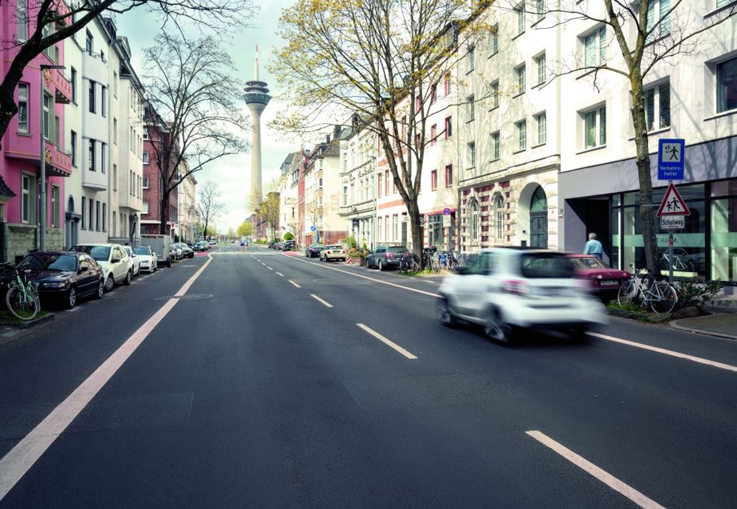 Eine zweispurige Straße in Unterbilk eröffnet den Blick auf den Düsseldorfer Rheinturm. 