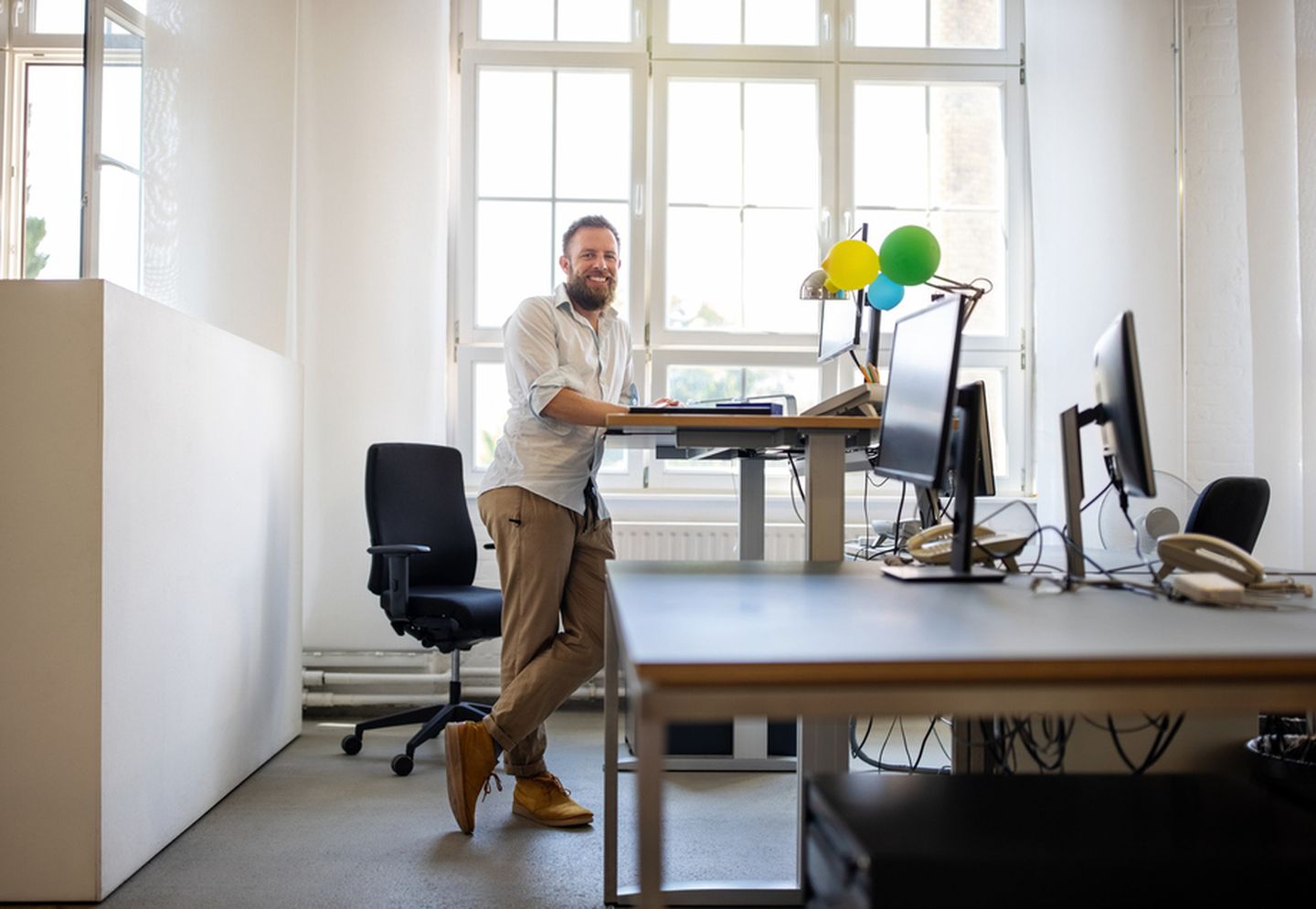 Mitarbeiter steht an ergonomischem Arbeitsplatz