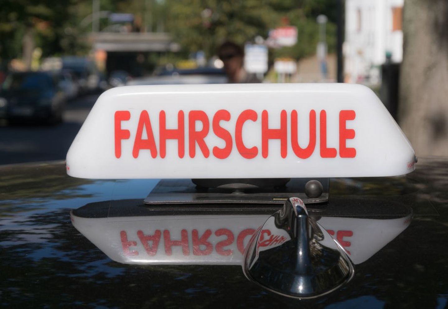 Ein Fahrschulauto mit Schild auf dem Dach