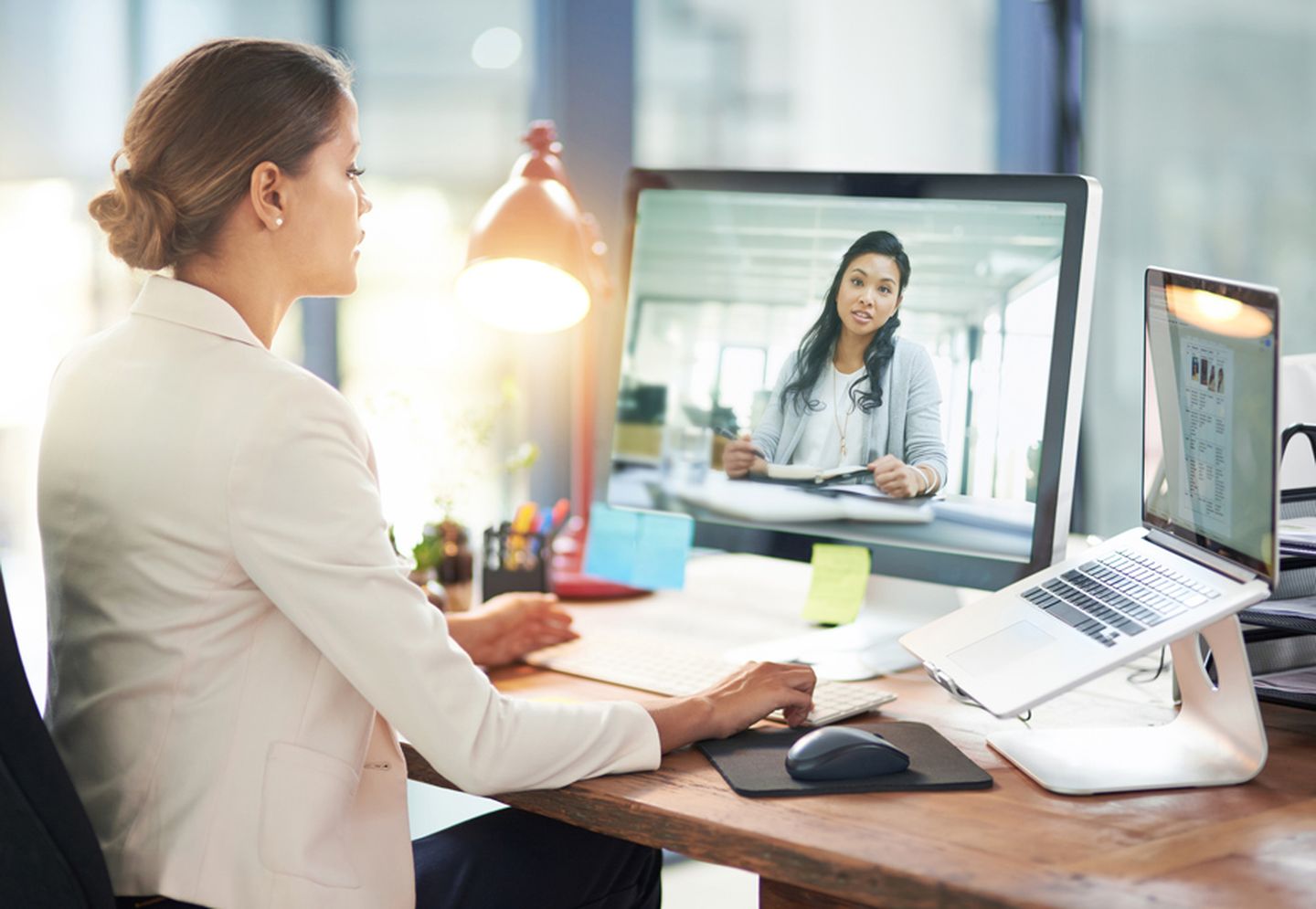Digital Leadership: Eine Frau kommuniziert mit ihrer Arbeitskollegin via Videocall.