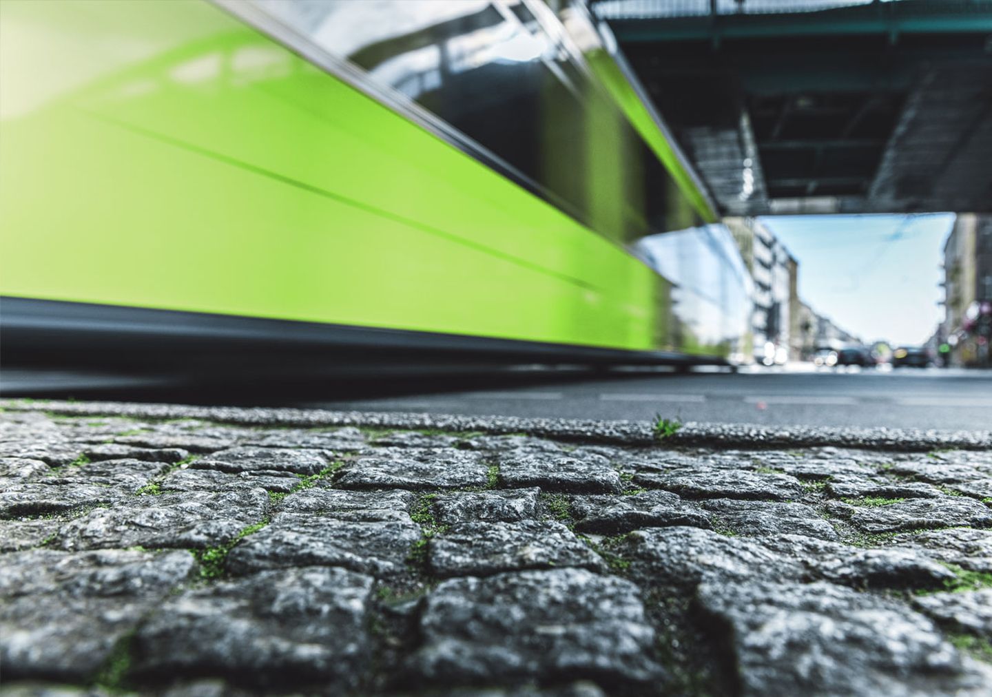 Eine Straßenbahn fährt in Düsseldorf mit Tempo unter einer Brücke hindurch