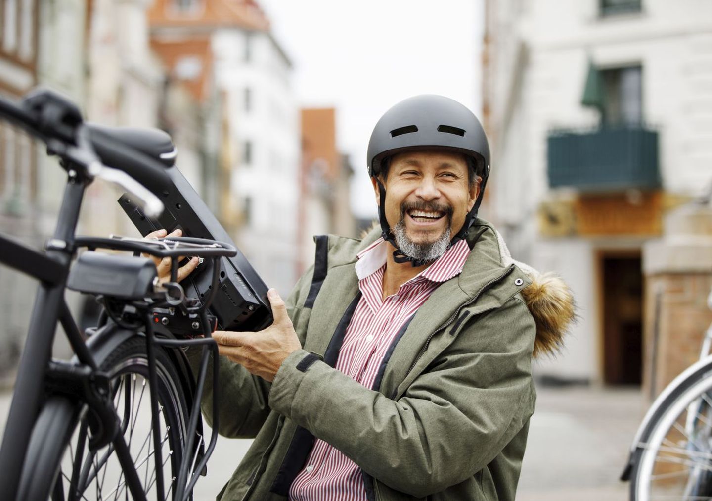 Mann tauscht den Akku an seinem E-Bike aus © Solskin / DigitalVision