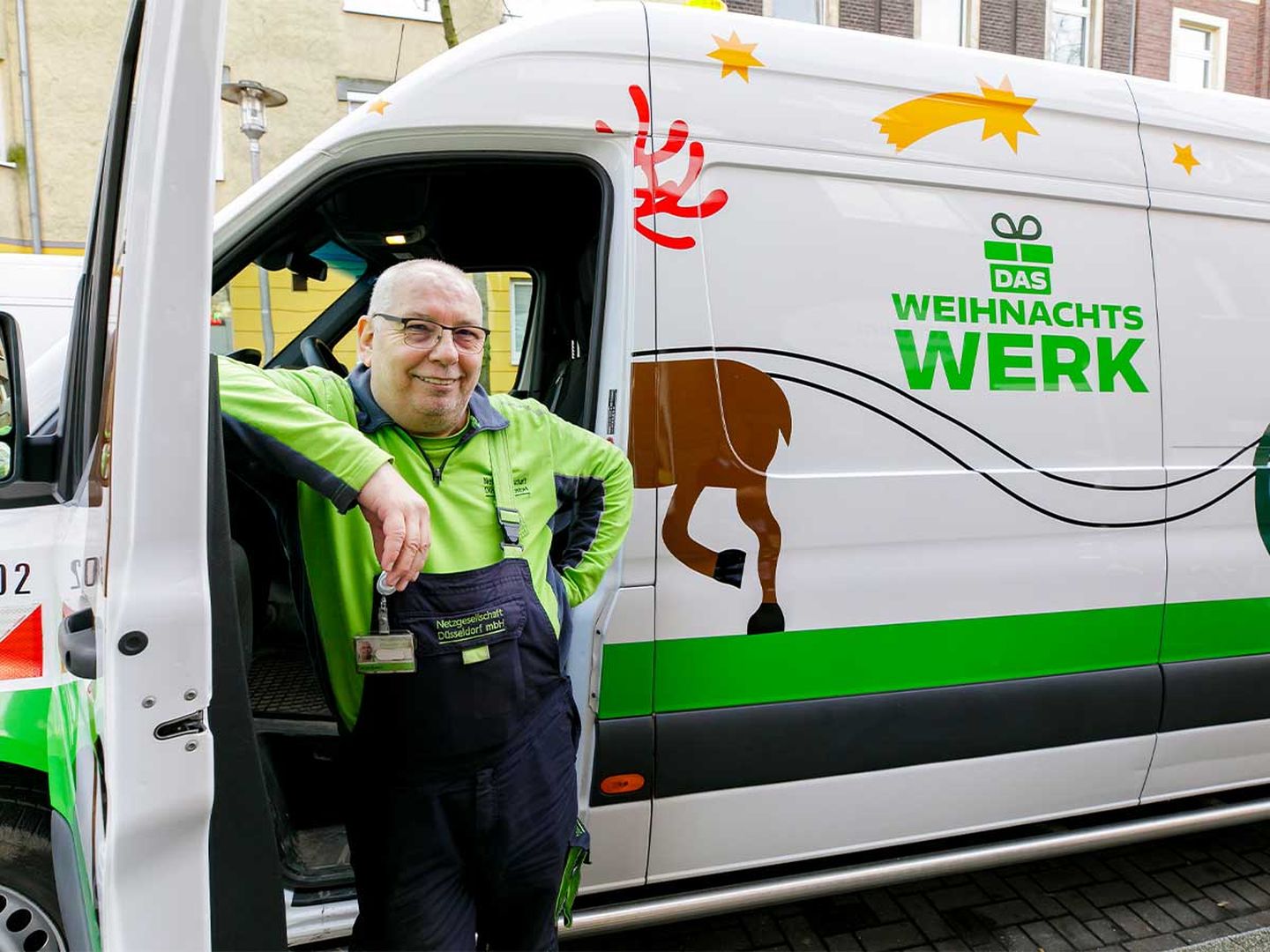Ein Fahrer vor der geöffneten Tür des Weihnachtswerk-Mobils