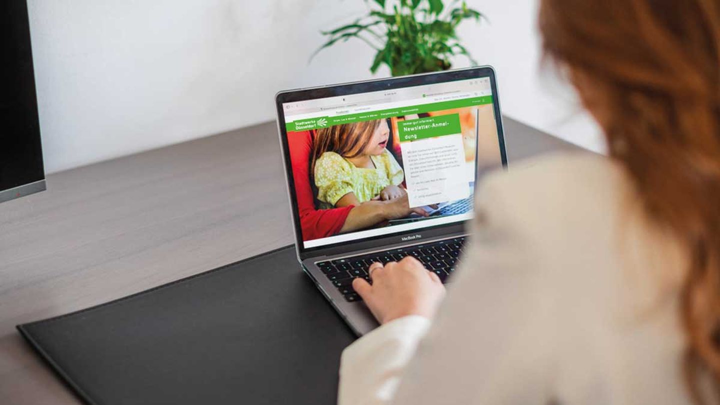 Eine rothaarige Frau besucht die Website der Stadtwerke Düsseldorf