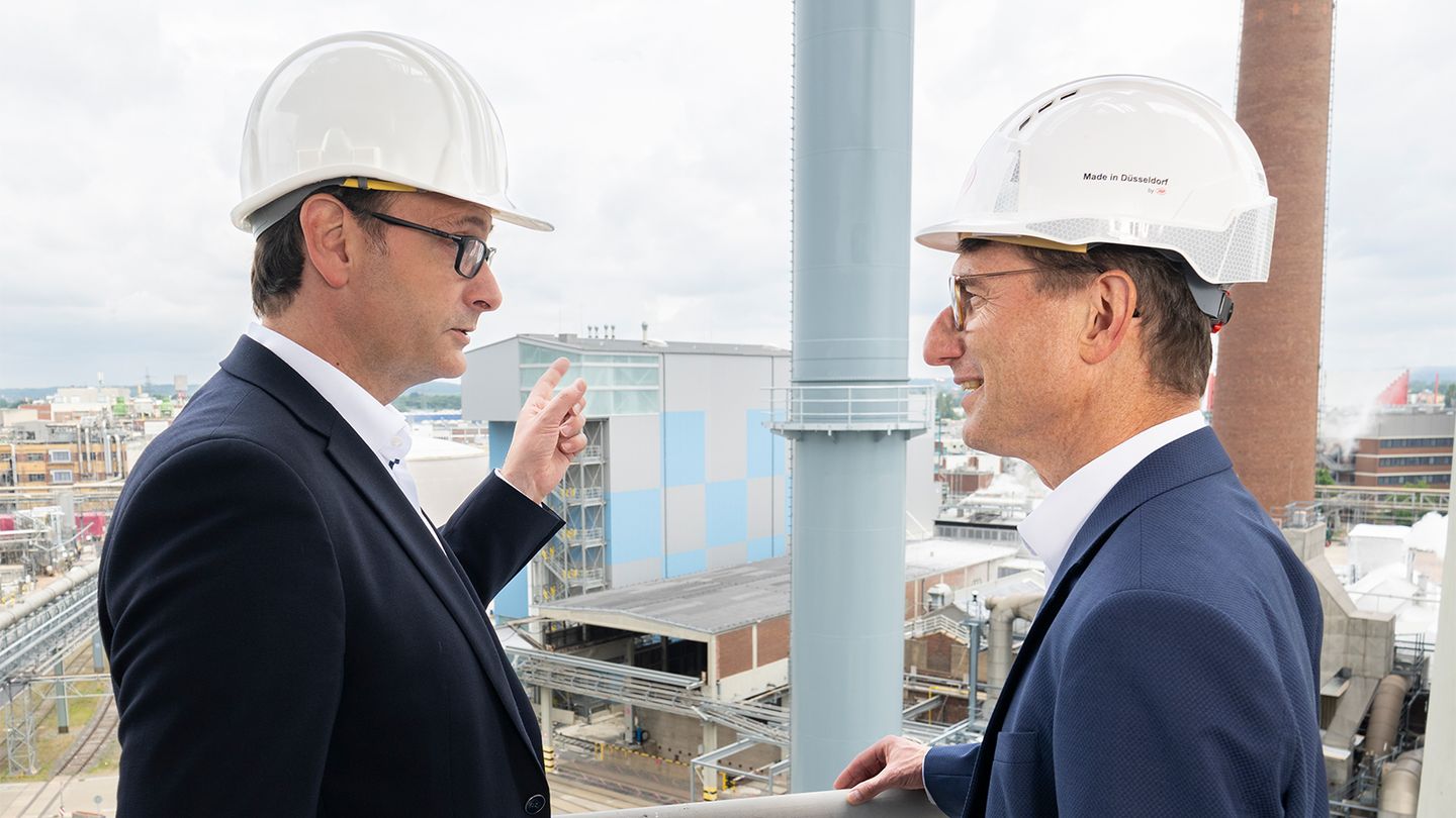 Julien Mounier (li.), Vorstandsvorsitzender der Stadtwerke Düsseldorf, und Dr. Daniel Kleine, Henkel President Germany und Standortleiter Düsseldorf, auf der Baustelle der Energiezentrale auf dem Henkel-Gelände. Mit dem Kamin wurde jetzt das Herzstück der Anlage fertiggestellt. Foto: Daniel Koke