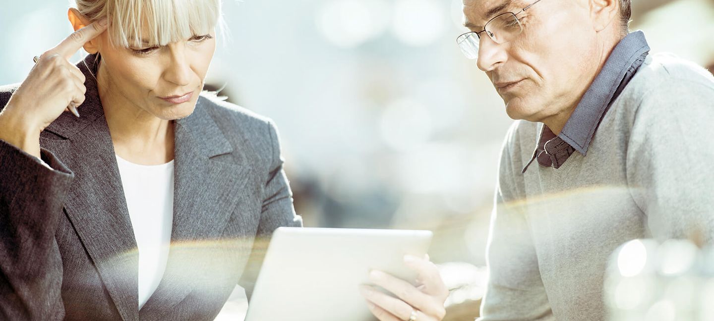 Energiedatenmanagement: zwei Personen diskutiern am Tisch mit einem Notebook