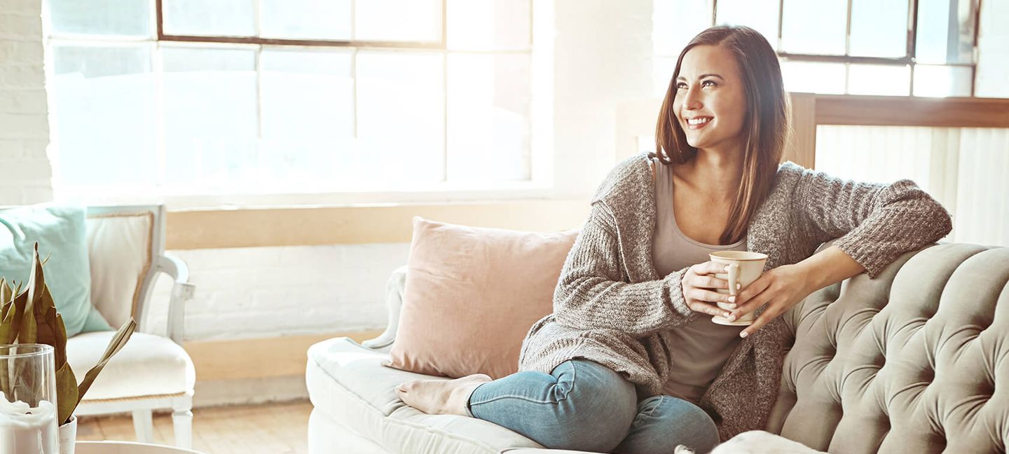 Eine Frau sitzt auf einer Couch mit ihrem Hund