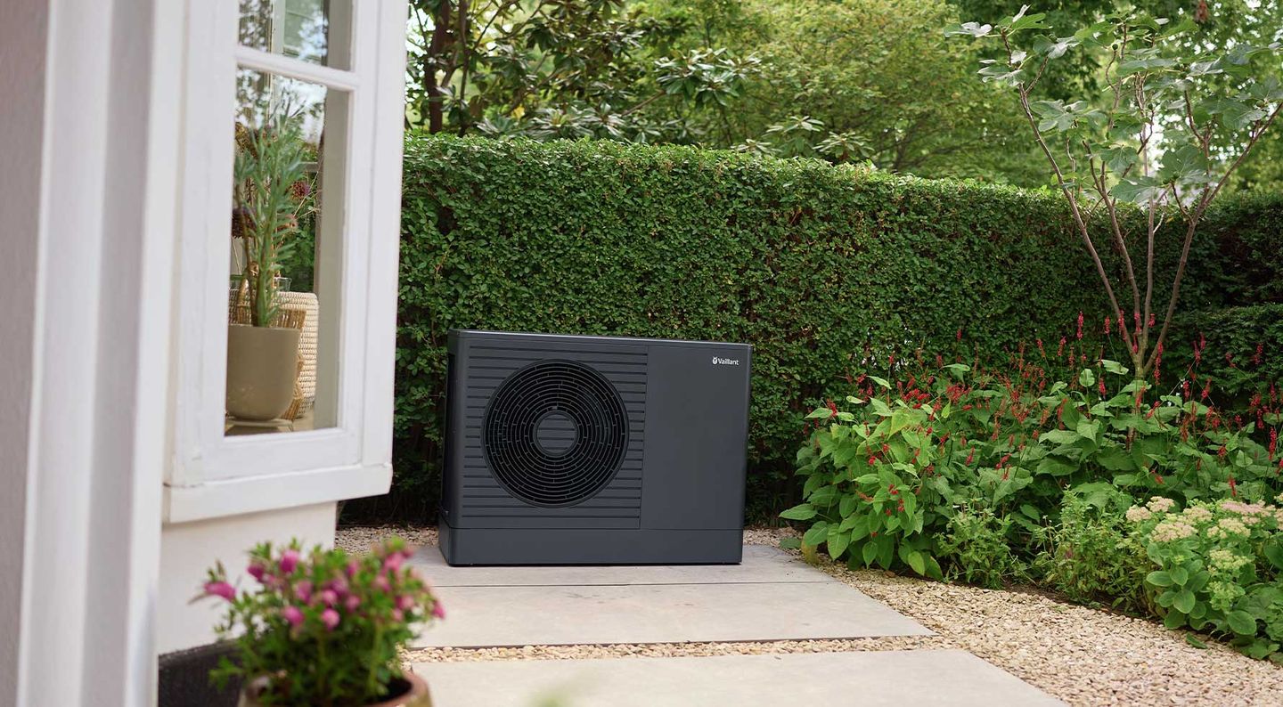 Eine schwarze Vaillant Wärmepumpe in einem Garten © Vaillant
