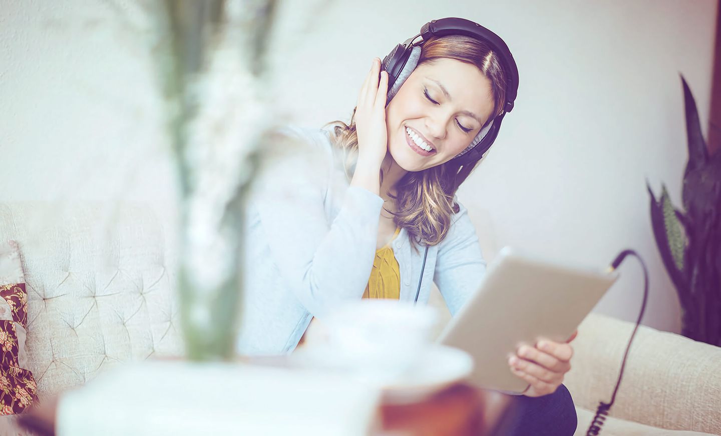 Eine Frau hört Musik über Kopfhörer von einem Tablet