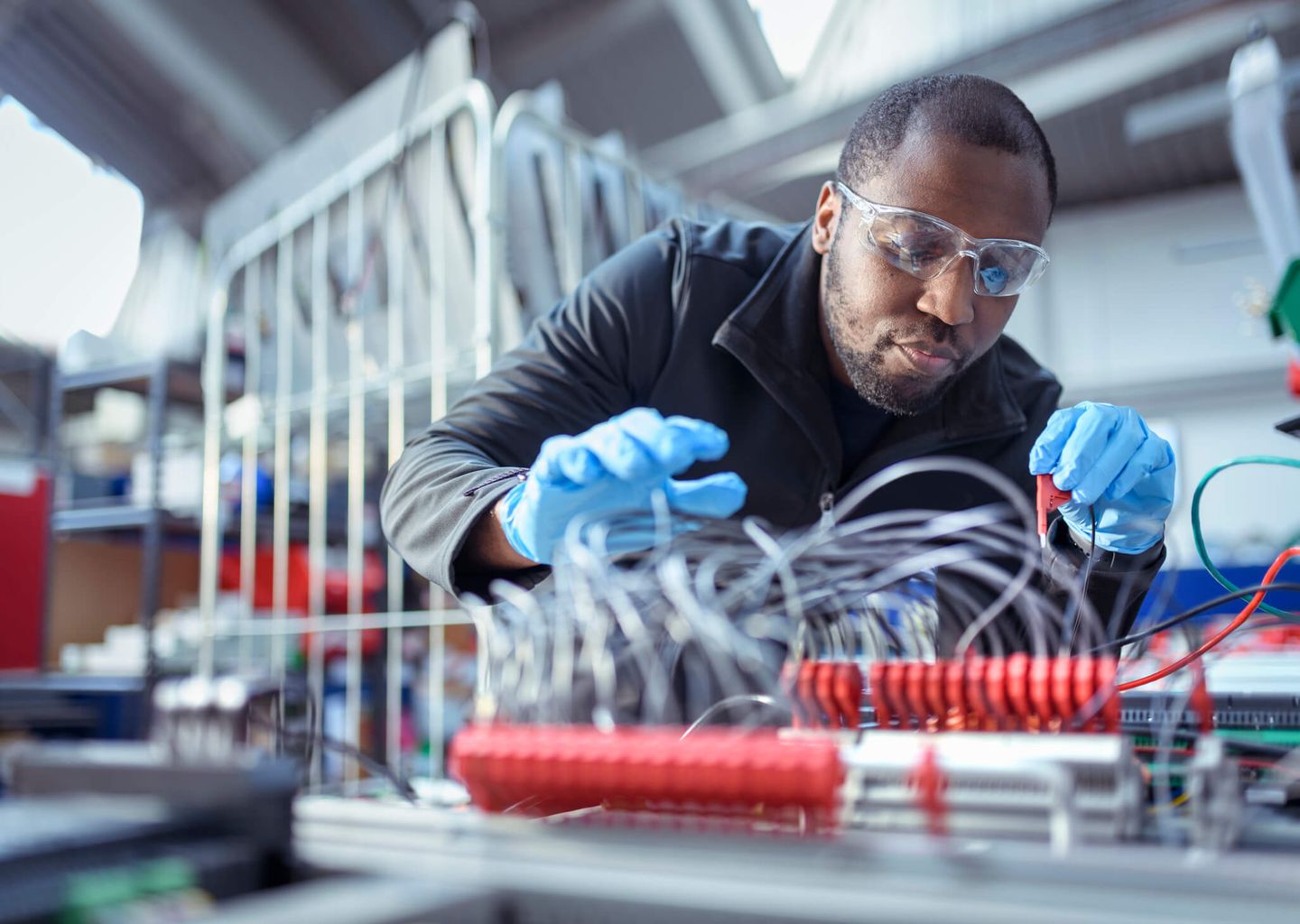 Ein Ingenieur baut in einer Werkstatt Elektronikteile zusammen.