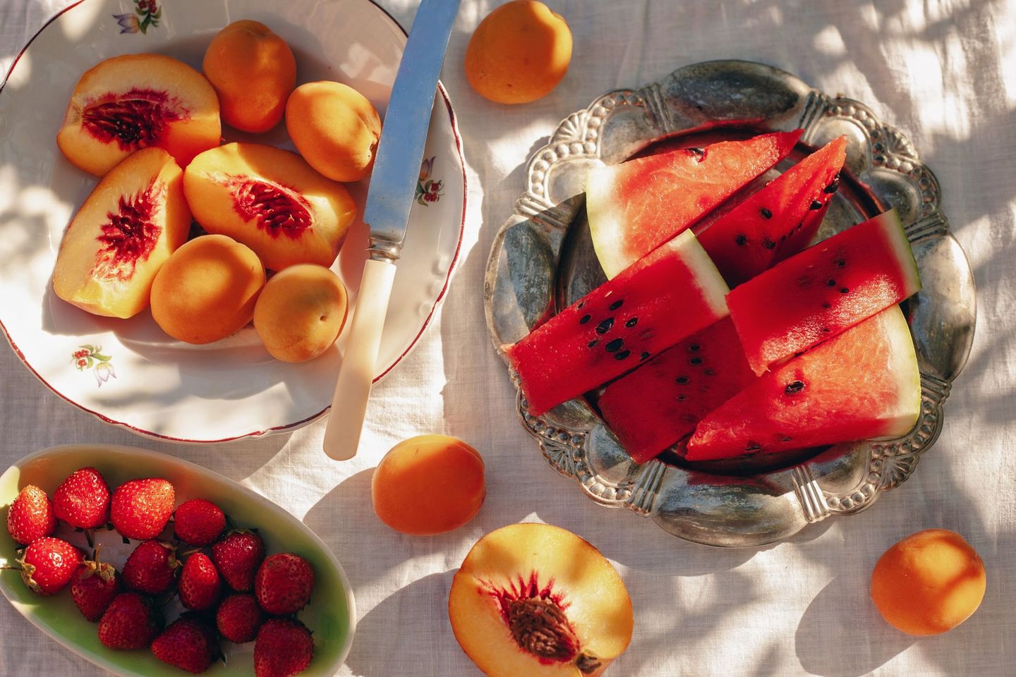 Eine Auswahl an frischen Sommerfrüchten liegt auf einem Tisch in der Sonne. © by vesi_127 / Moment via Getty Images © by vesi_127 / Moment via Getty Images