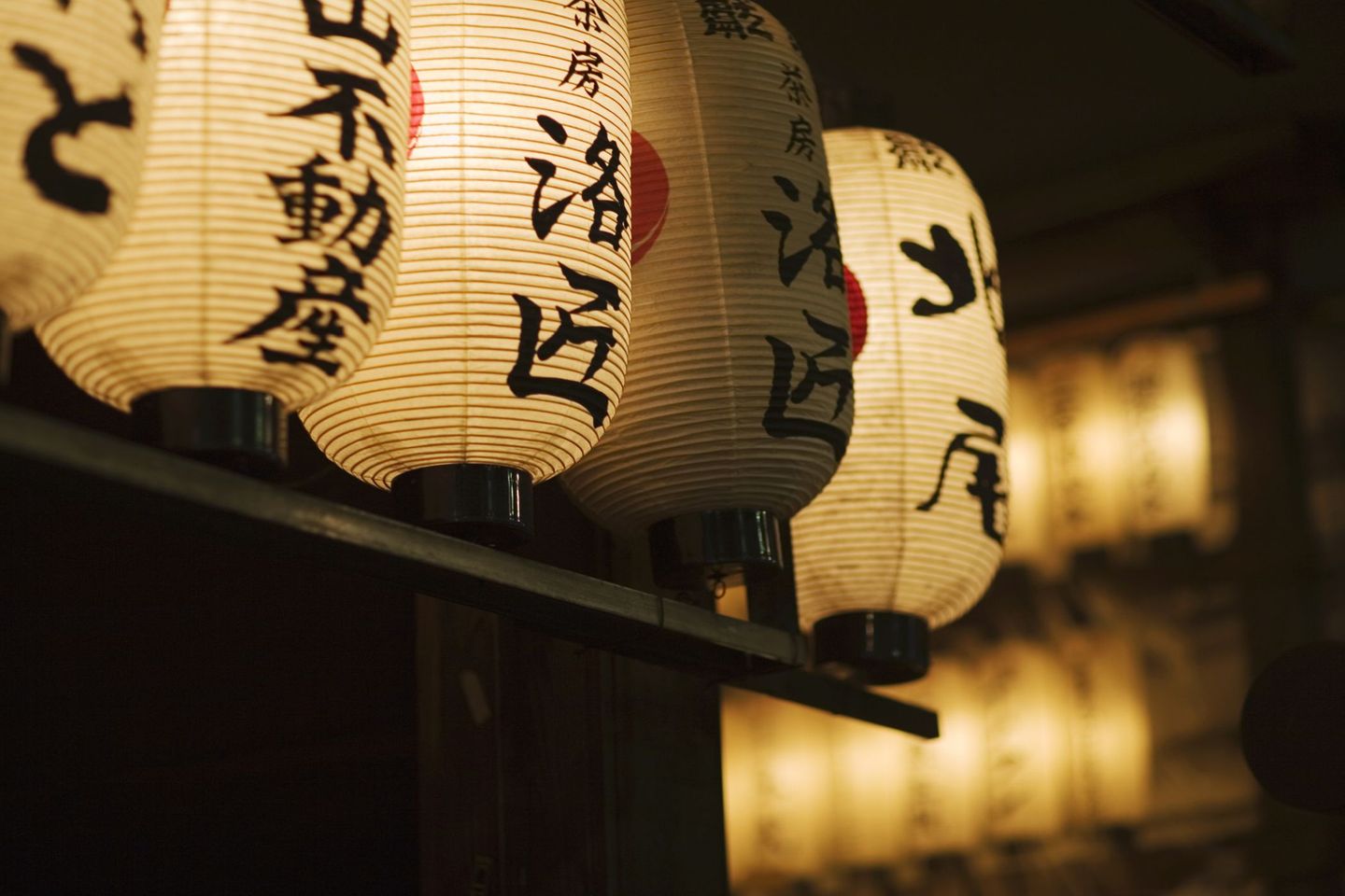 Japanische Papierlampen hängen im Dunkeln © Matt Henry Gunther / The Image Bank via Getty Images © Matt Henry Gunther / The Image Bank via Getty Images