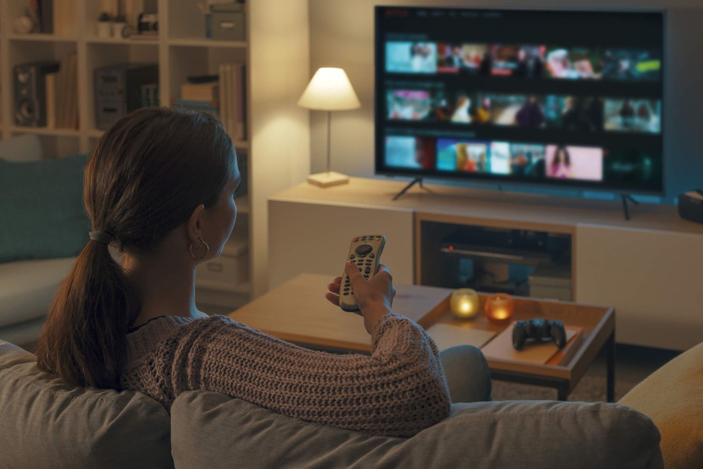 Frau sitzt auf dem Sofa und schaut Fernsehen.© demaerre / iStock / Getty Images Plus
