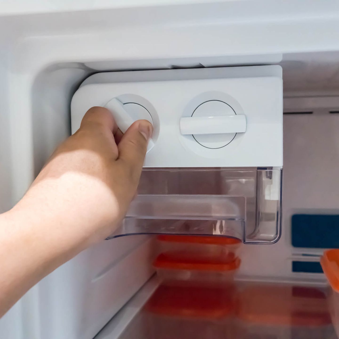 Person stellt den Temperaturregler im Gefrierfach ein. © Vudhikul Ocharoen / iStock / Getty Images Plus via Getty Images