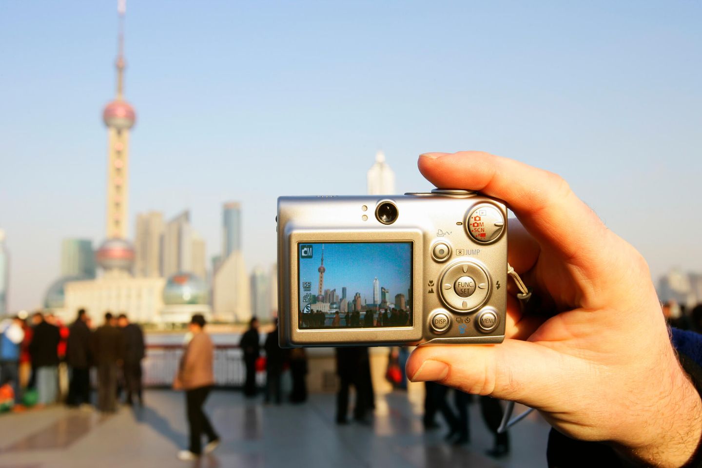 Ein Mann fotografiert eine Skyline mit einer Digitalkamera.