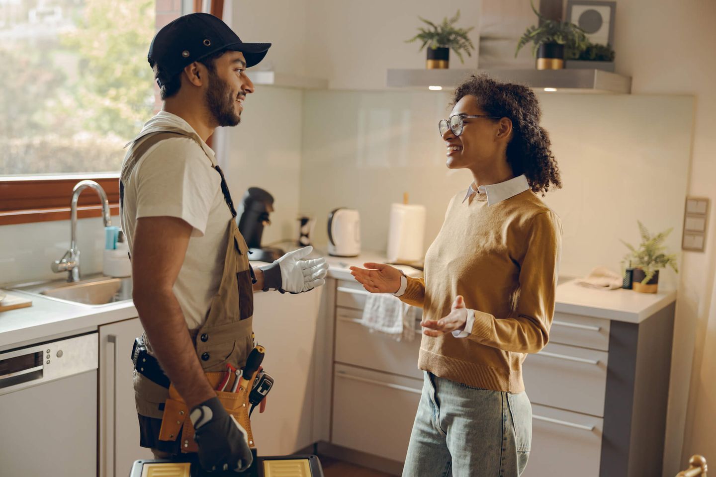 Elektriker spricht mit Kundin in ihrer Küche. © Voronchuk Daria / iStock / Getty Images Plus via Getty Images © Voronchuk Daria / iStock / Getty Images Plus via Getty Images