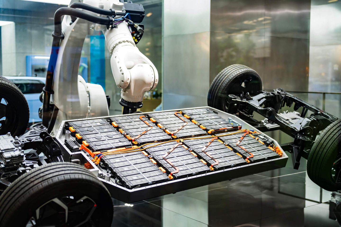 Ein Roboterarm installiert Batterien in einem Gestell eines Elektroautos. © Witthaya Prasongsin / Moment via Getty Images