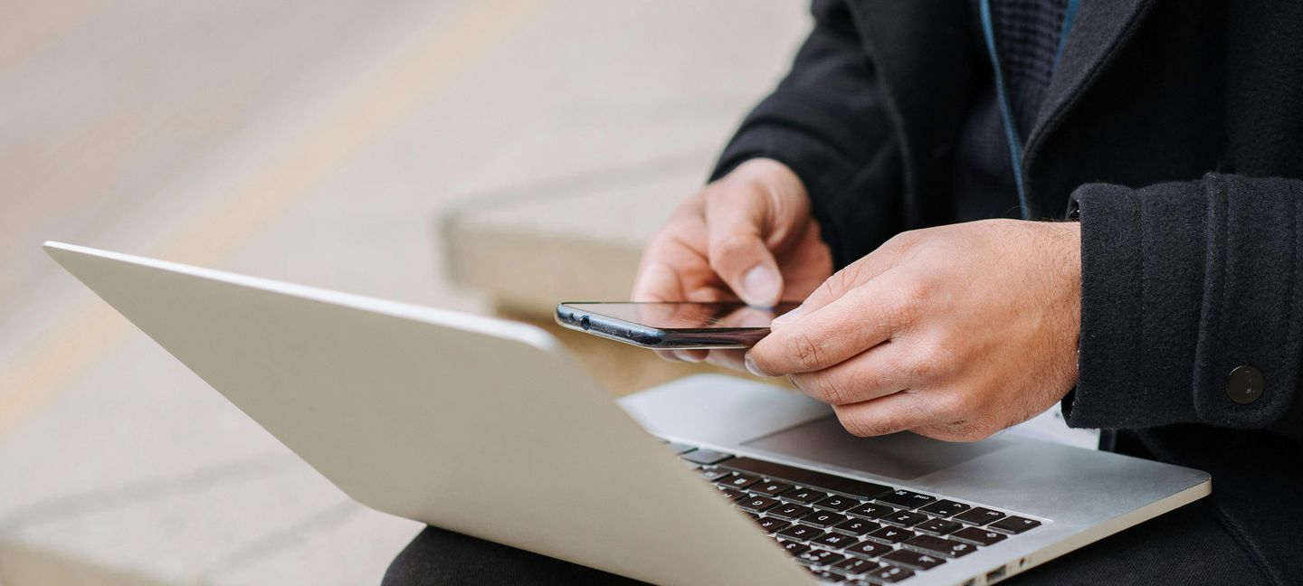 Manager mit Laptop, der auf städtischen Treppen auf dem Smartphone chattet @anete-lusina via via Pexels