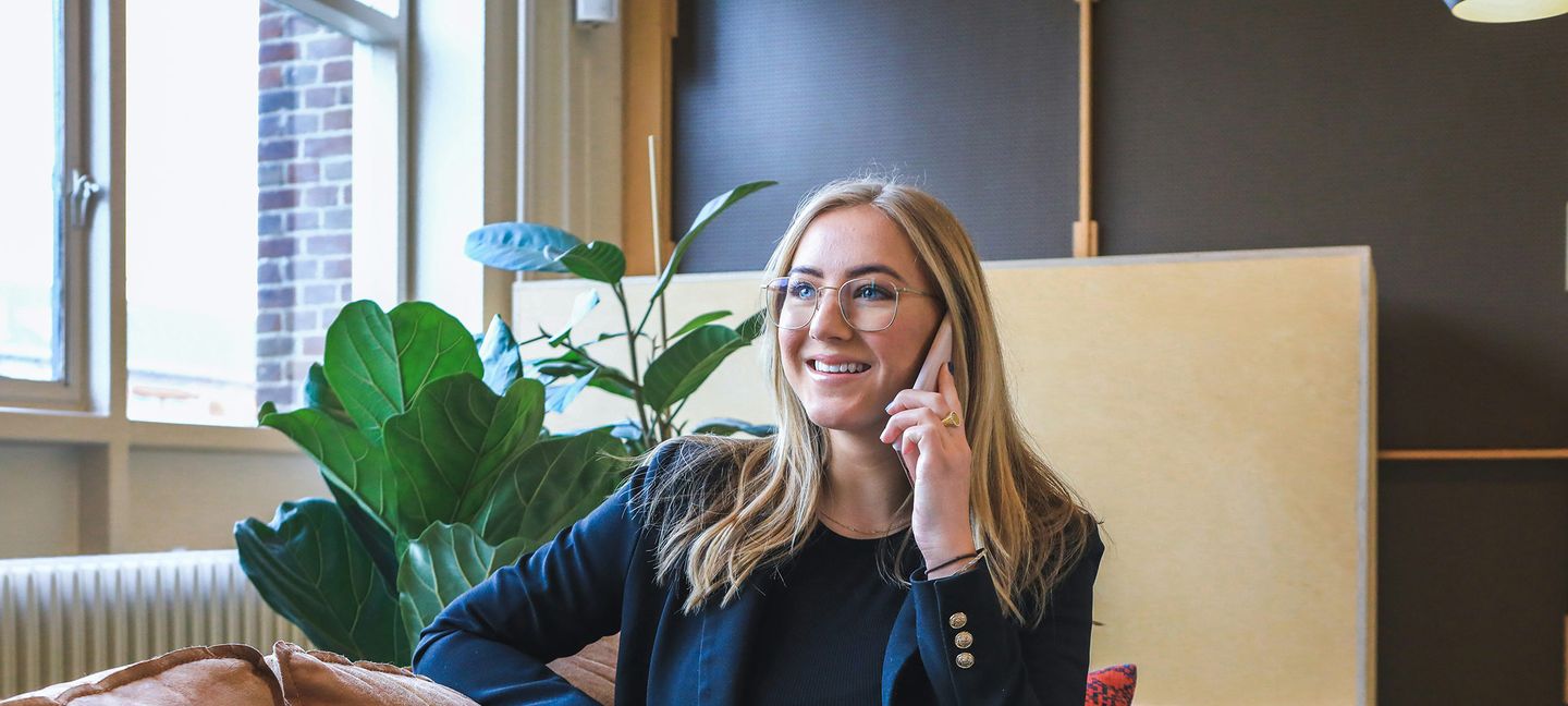 Eine Frau sitzt auf der Couch und telefoniert