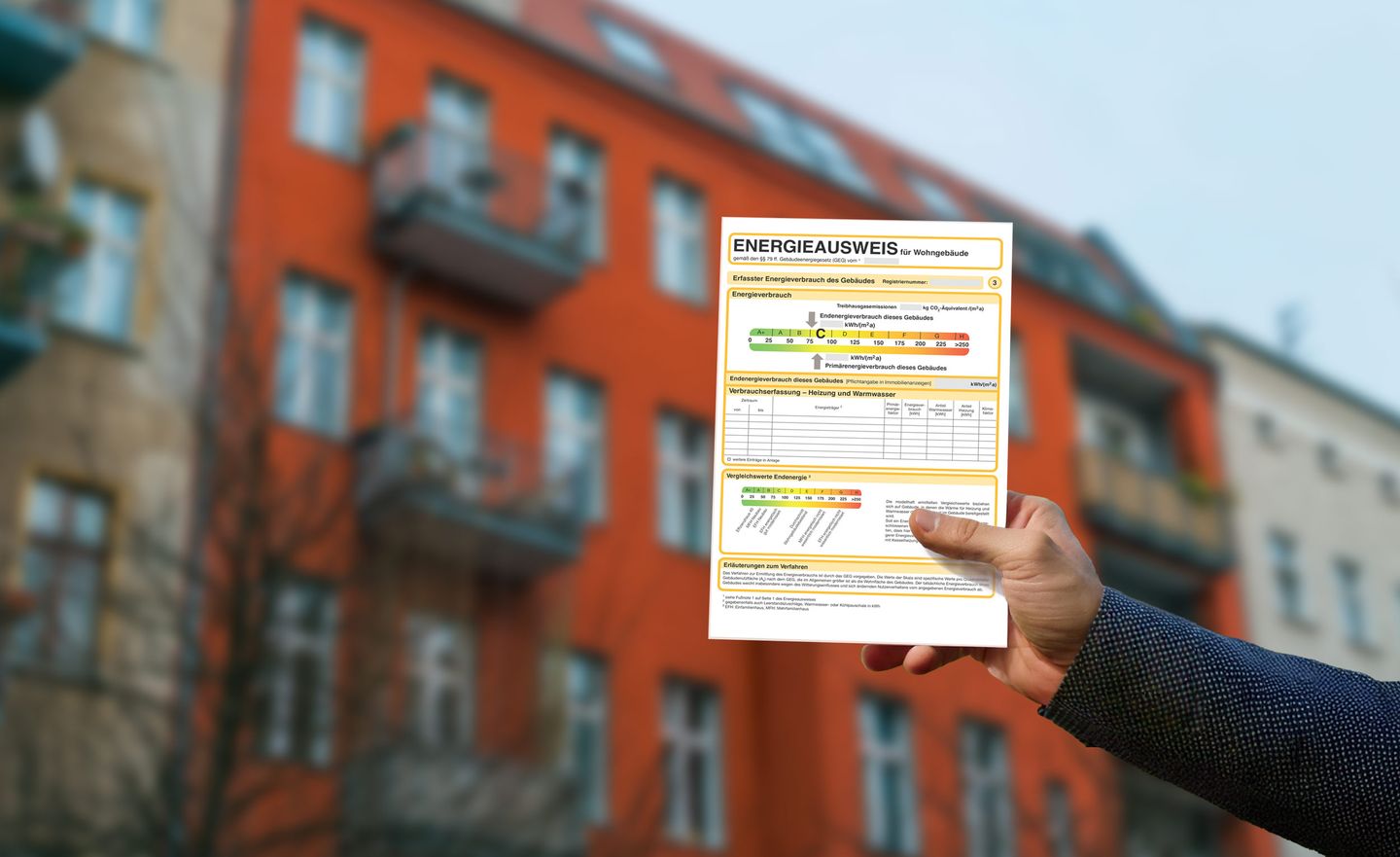 Ein Verbrauchsausweis vor einer roten Häuserfassade
