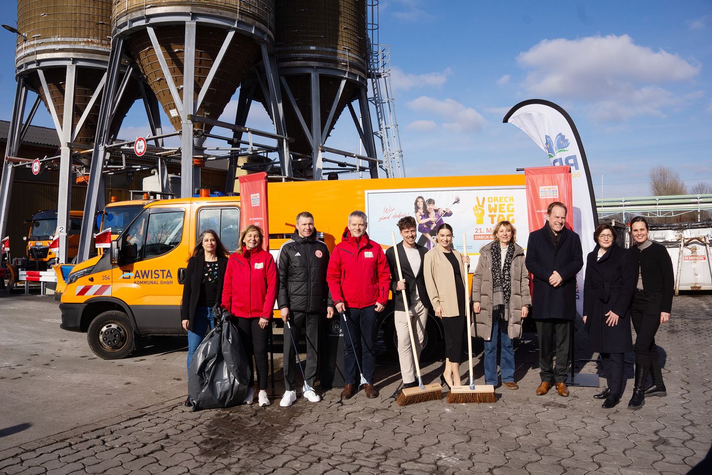 Eine Gruppe von Menschen steht mit Besen, Greifzangen und Mülltüten ausgestattet vor einem Müllwagen. © Pro Düsseldorf e. V. © Pro Düsseldorf e. V.