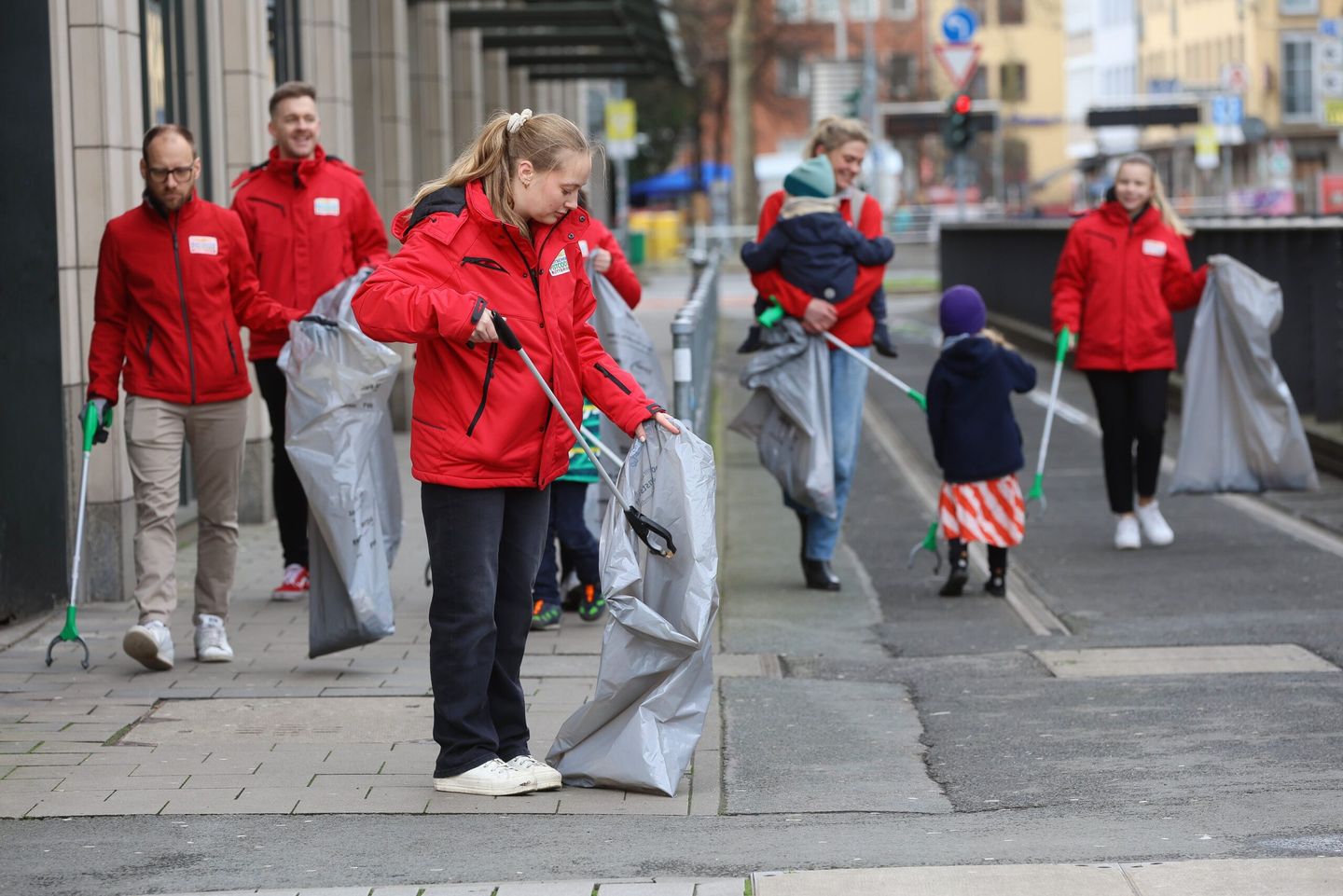 Eine Gruppe Erwachsener und Kinder sammeln gemeinsam Müll von einer Straße.  © Pro Düsseldorf e. V.