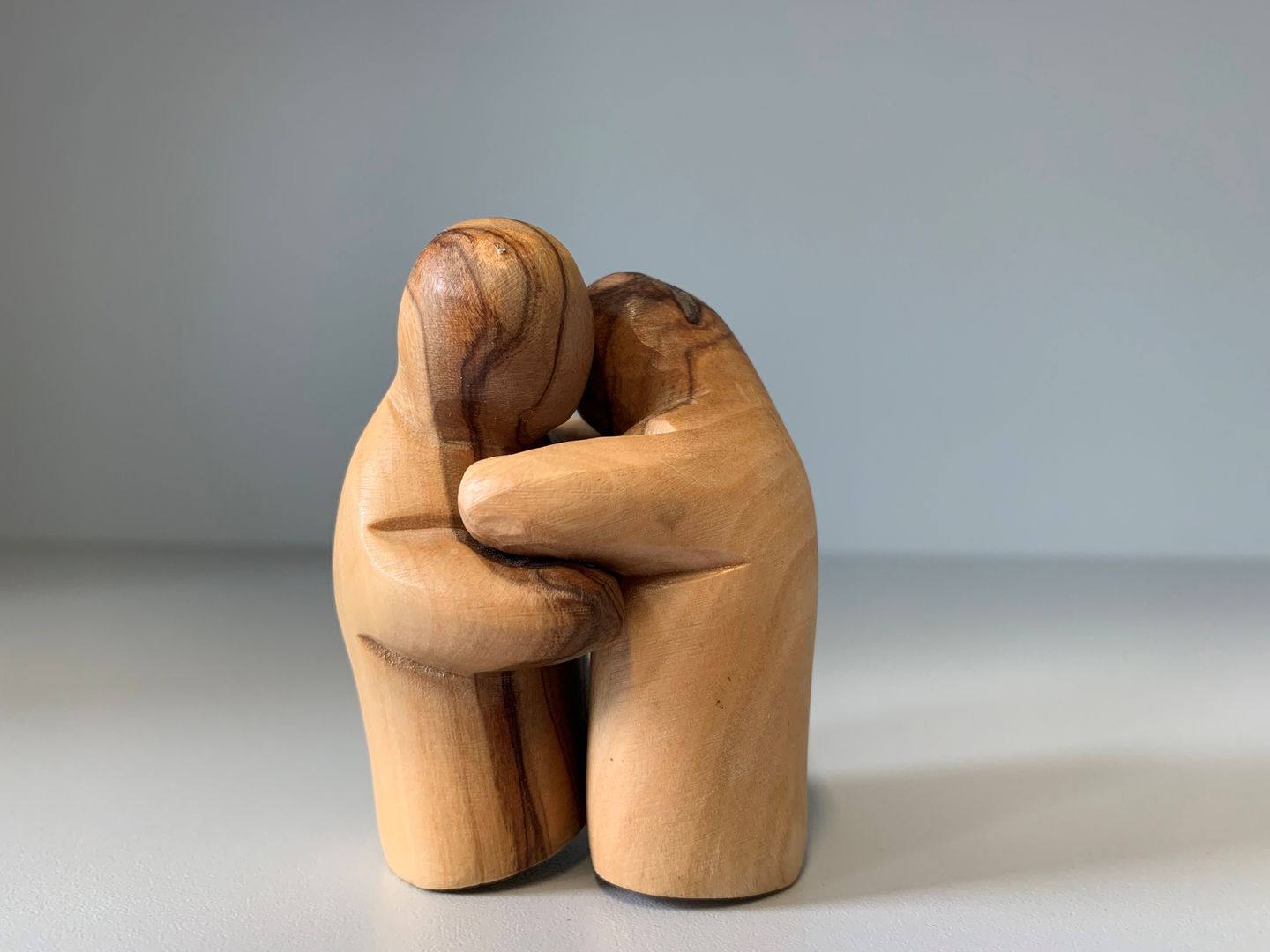 Zwei Statuen aus Holz, die sich umarmen