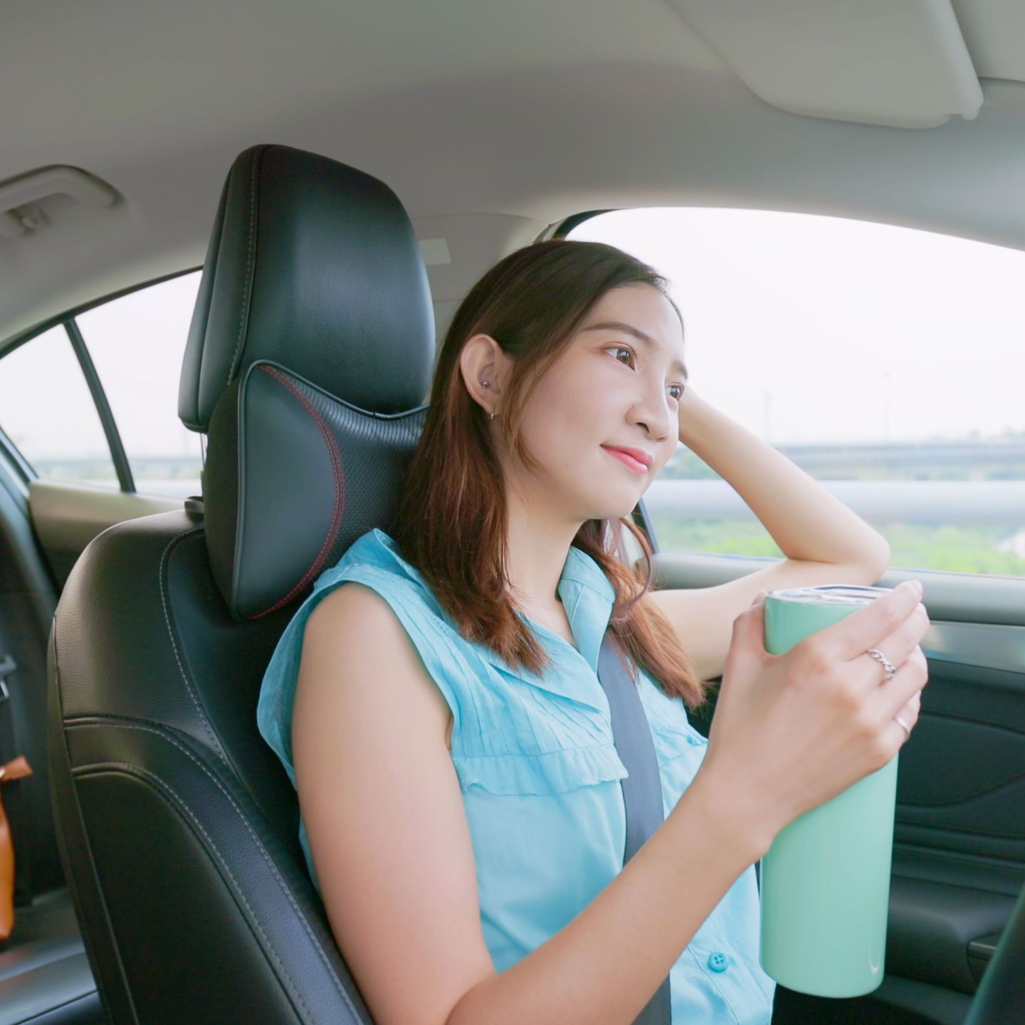 Eine Frau sitzt im Auto und hält einen Thermosbecher.  © PonyWang / E+ via Getty Images