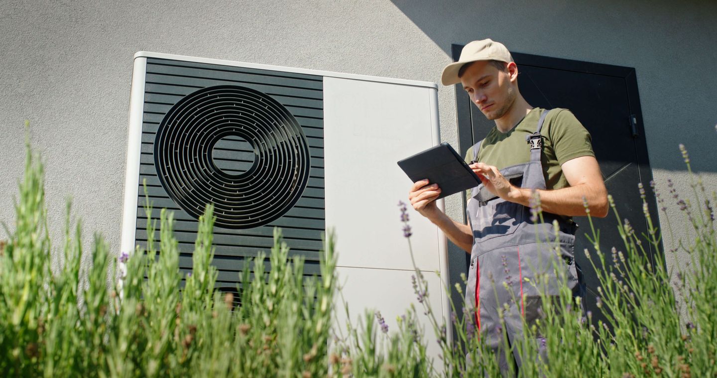 Techniker mit Tablet bei der Inspektion einer modernen Wärmepumpe. © StockSeller_ukr / iStock / Getty Images Plus via Getty Images