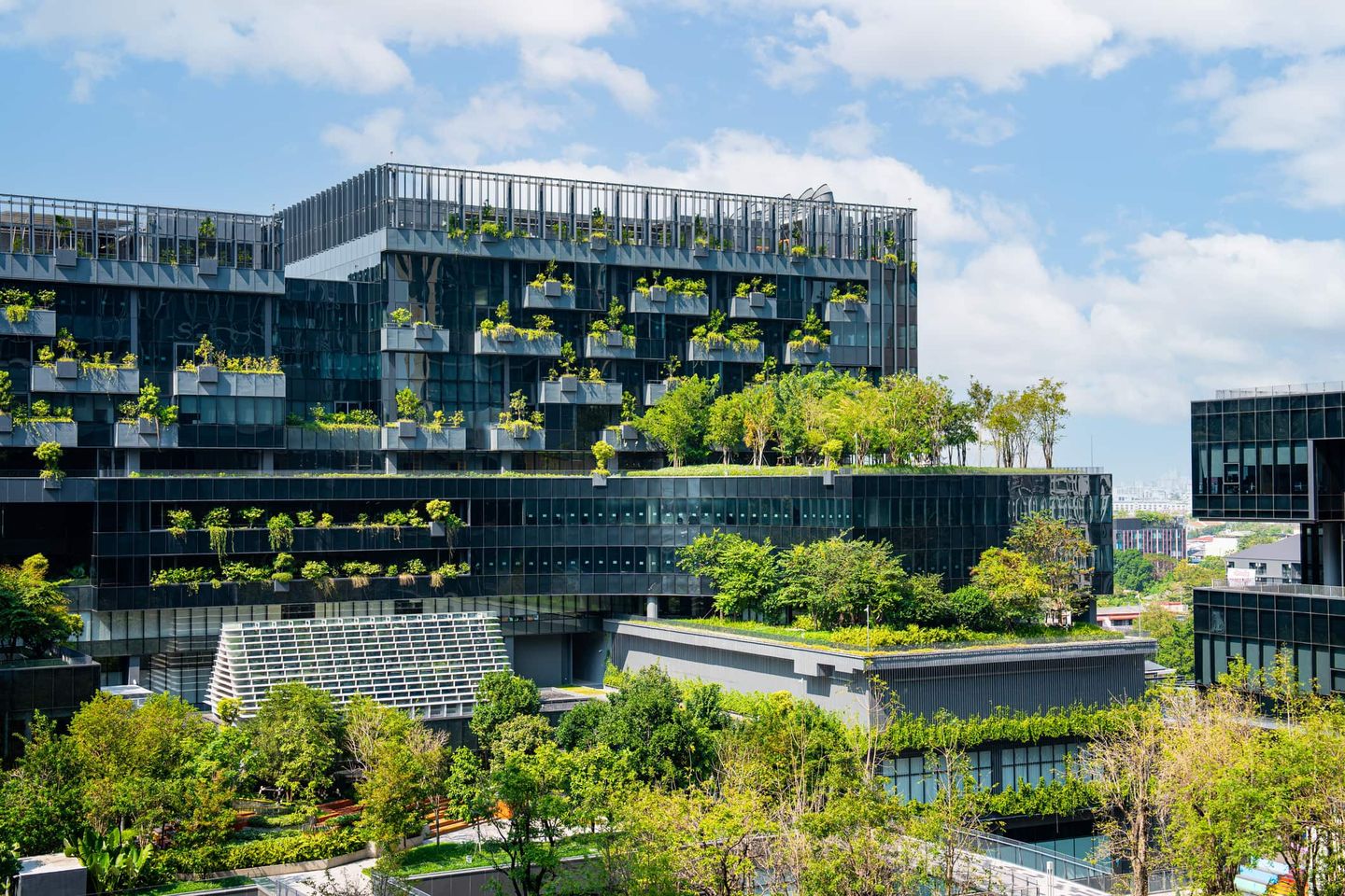 Modernes Bürogebäude mit üppiger Begrünung an Fassaden und Dachterrassen. Getty