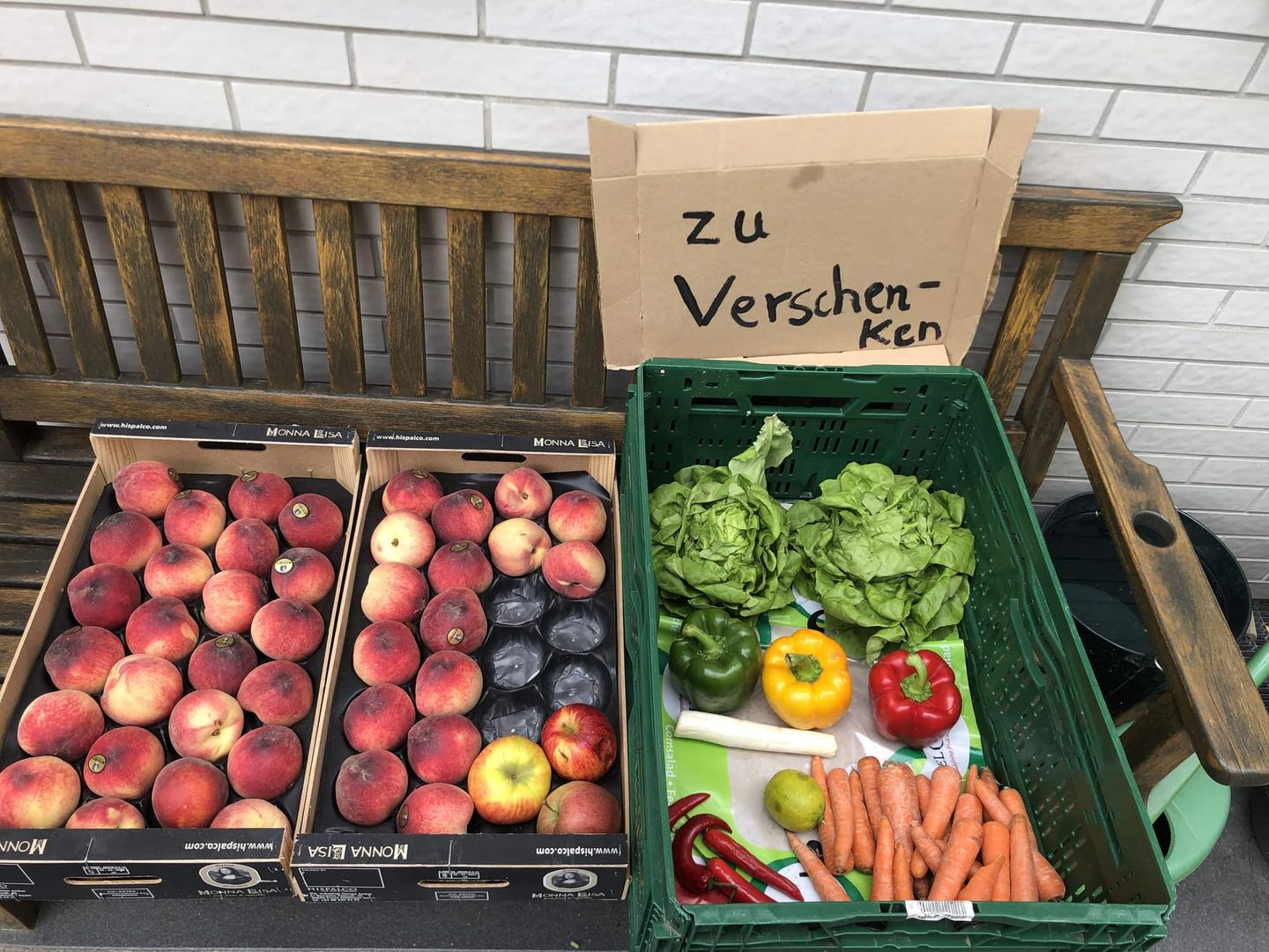 Kiste mit Obst und Gemüse, Schild mit „zu verschenken“ Getty