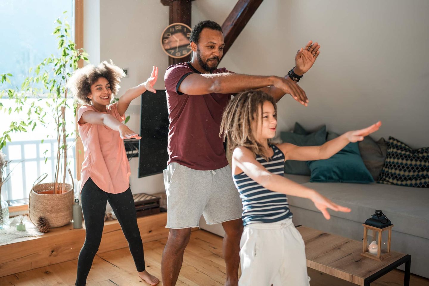 Vater und Kinder trainieren gemeinsam im Wohnzimmer Getty