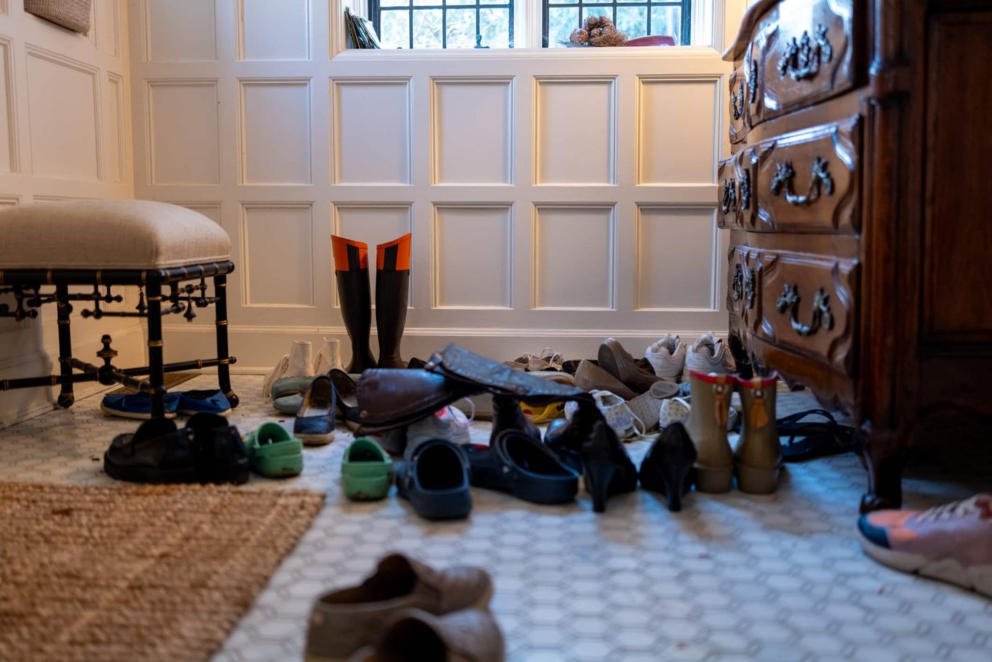 Viele unterschiedliche Schuhe stehen im Eingangsbereich eines Hauses nebeneinander. Getty