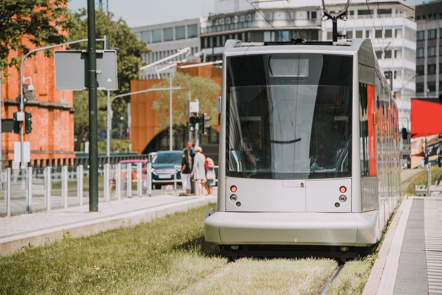 Straßenbahn fährt durch die Innenstadt auf begrüntem Gleisbett. Getty