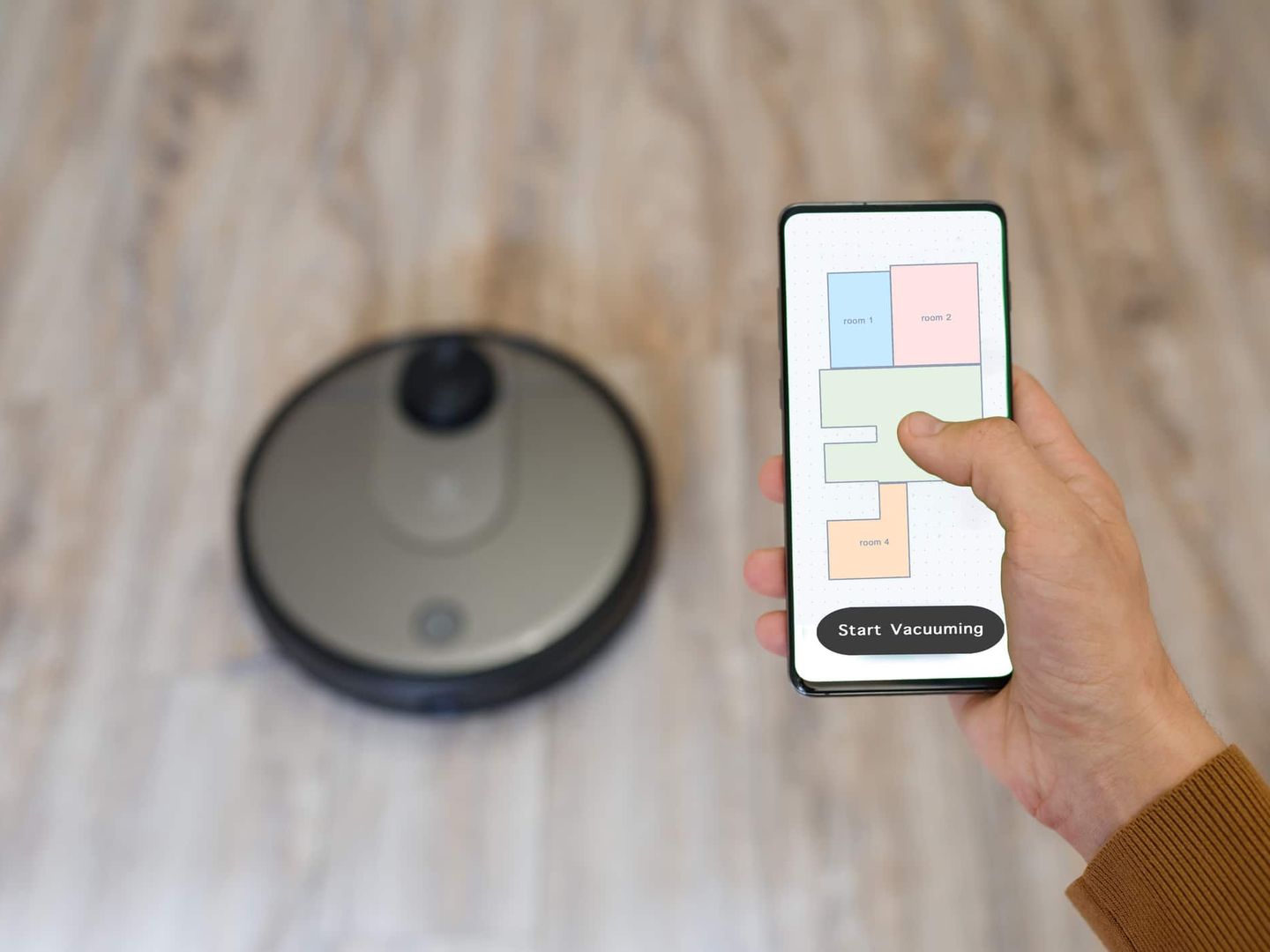 Hand bedient Staubsaugerroboter per Smartphone-App mit Raumkarte Getty