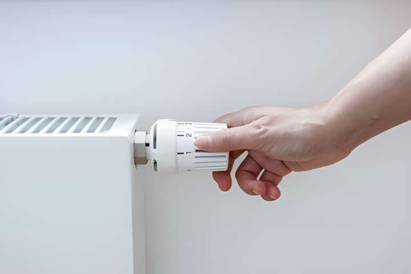 Thermografie am Haus: Hand bedient Temperaturregler an einer Heizung. © Amparo García / EyeEm via Getty Images © Amparo García / EyeEm via Getty Images via © Amparo García / EyeEm via Getty Images