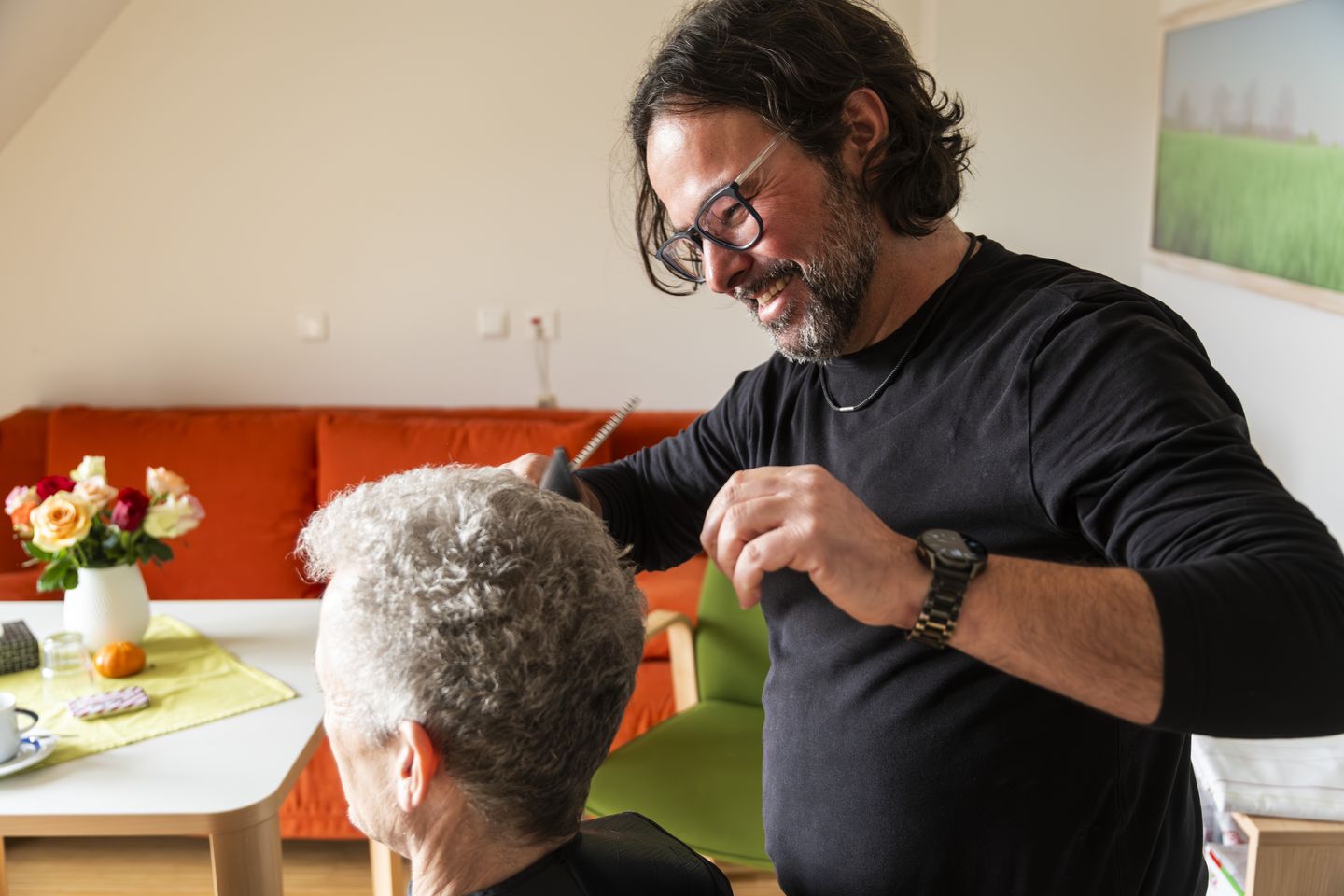 Ein Frisör schneidet einer Frau die Haare ©DHPF
