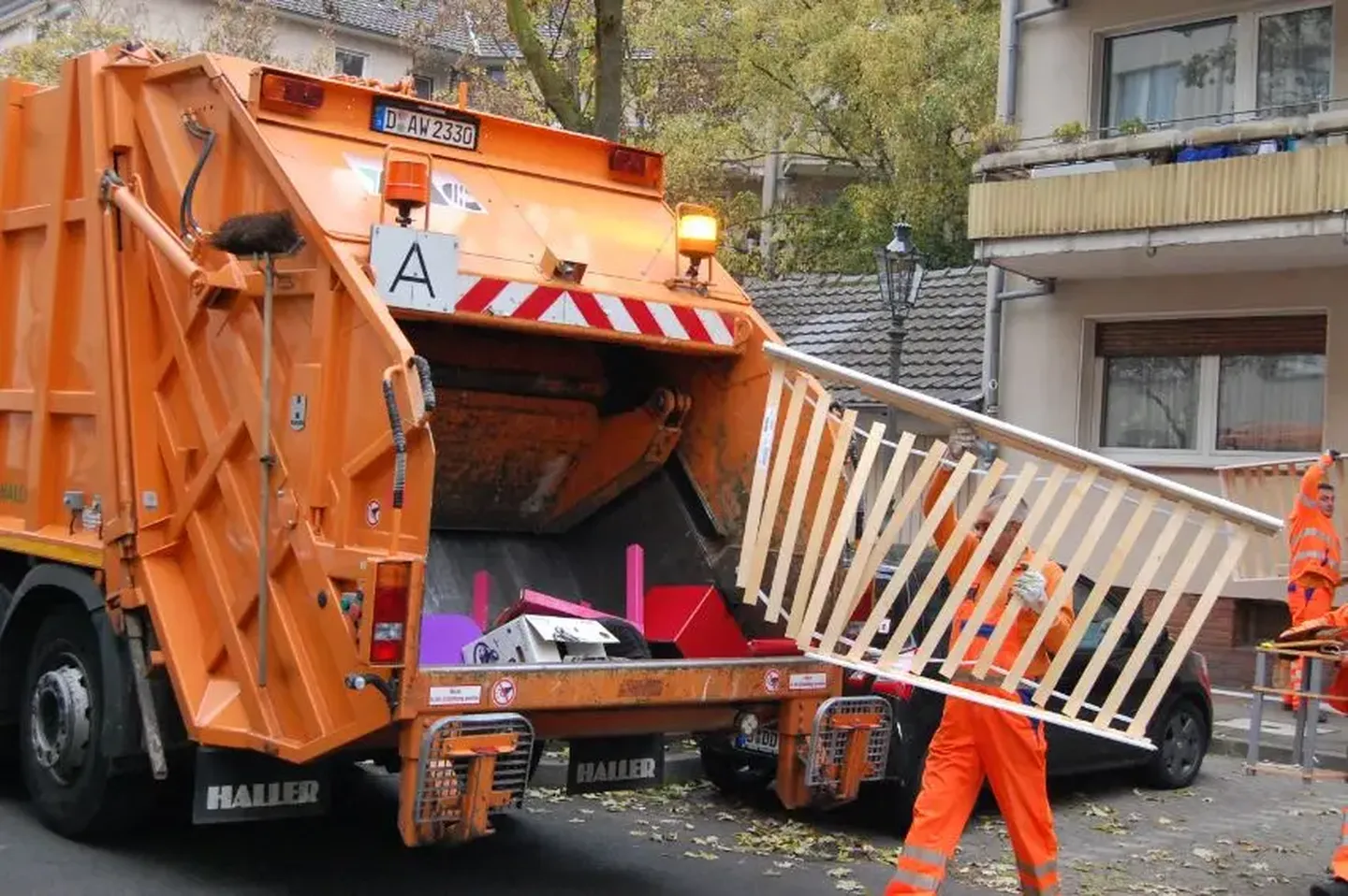 Mitarbeiter:innen der AWISTA Kommunal laden Möbel und weitere sperrige Haushaltsgegenstände in ein Sammelfahrzeug
