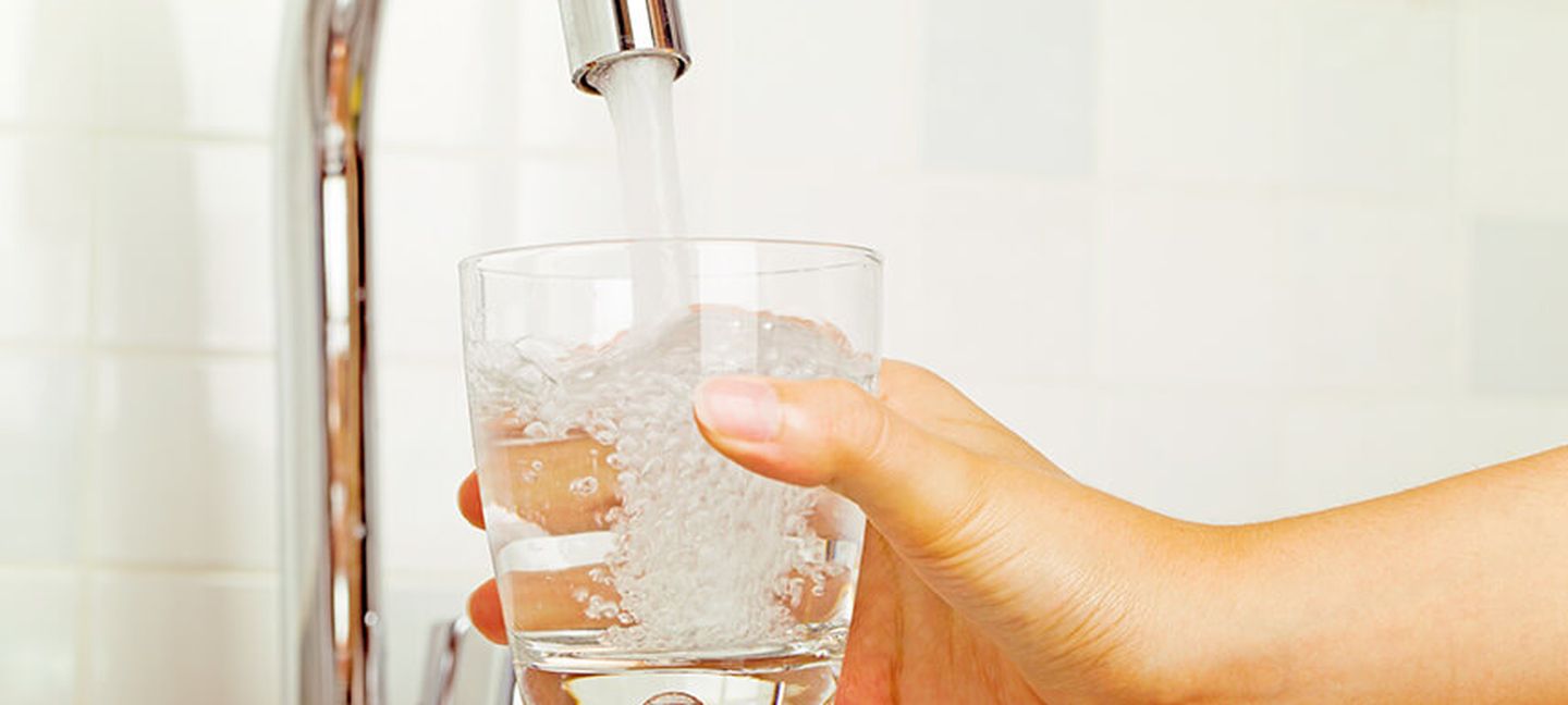 Ein Glas wird mit Leitungswasser gefüllt