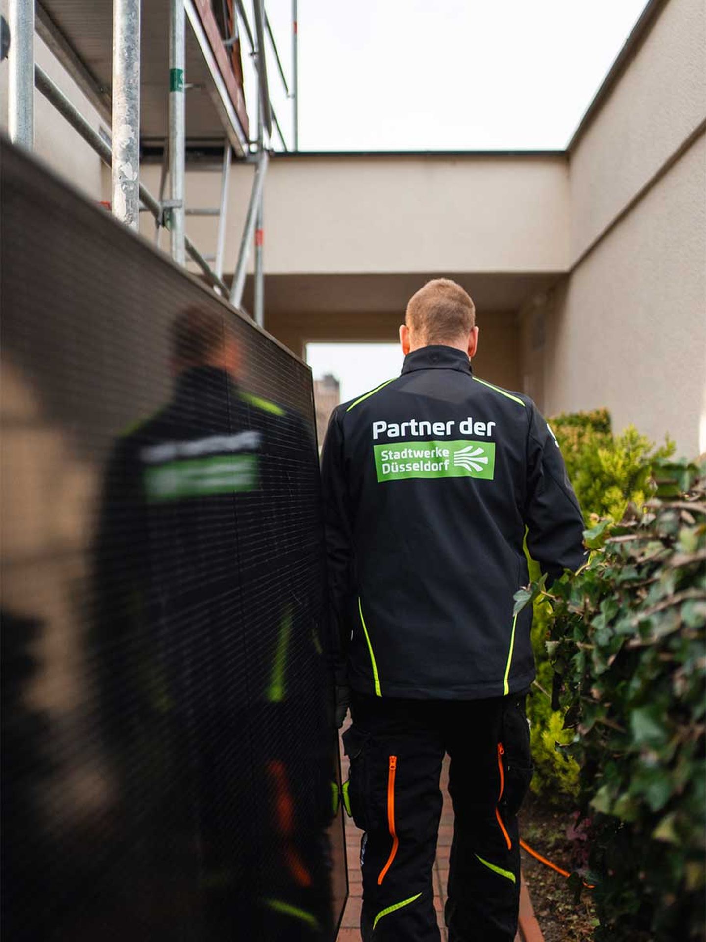 Ein Mann mit einer Jacke "Partner der Stadtwerke Düsseldorf"